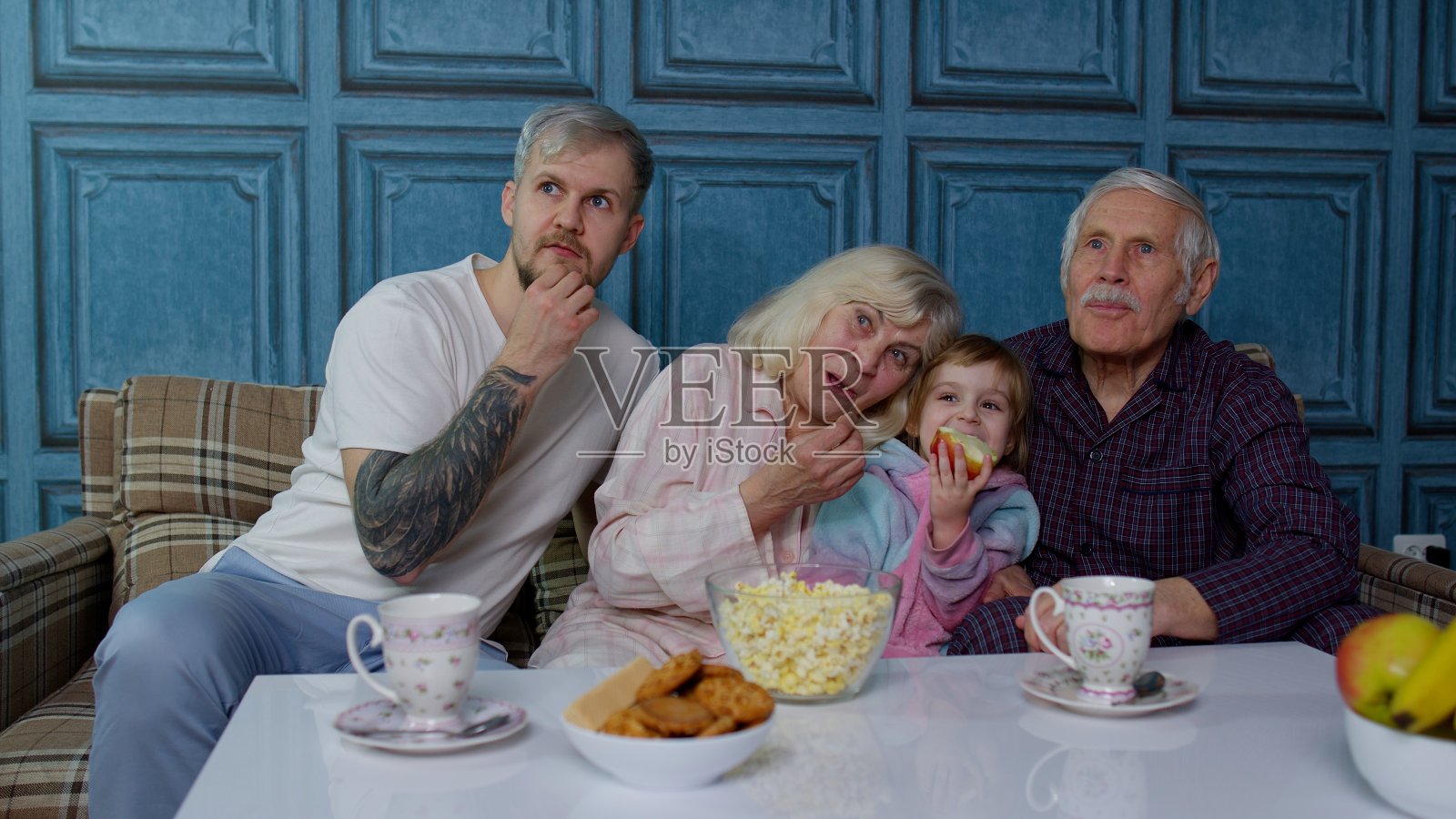 几代人一起看电视，小女孩在家里看恐怖电影照片摄影图片