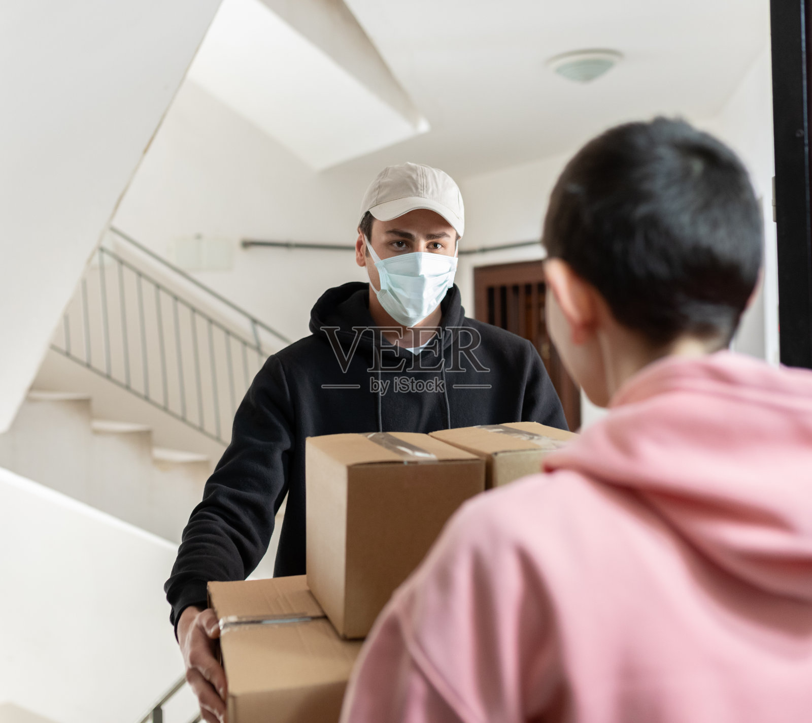 快递员带着防护面罩运送货物照片摄影图片