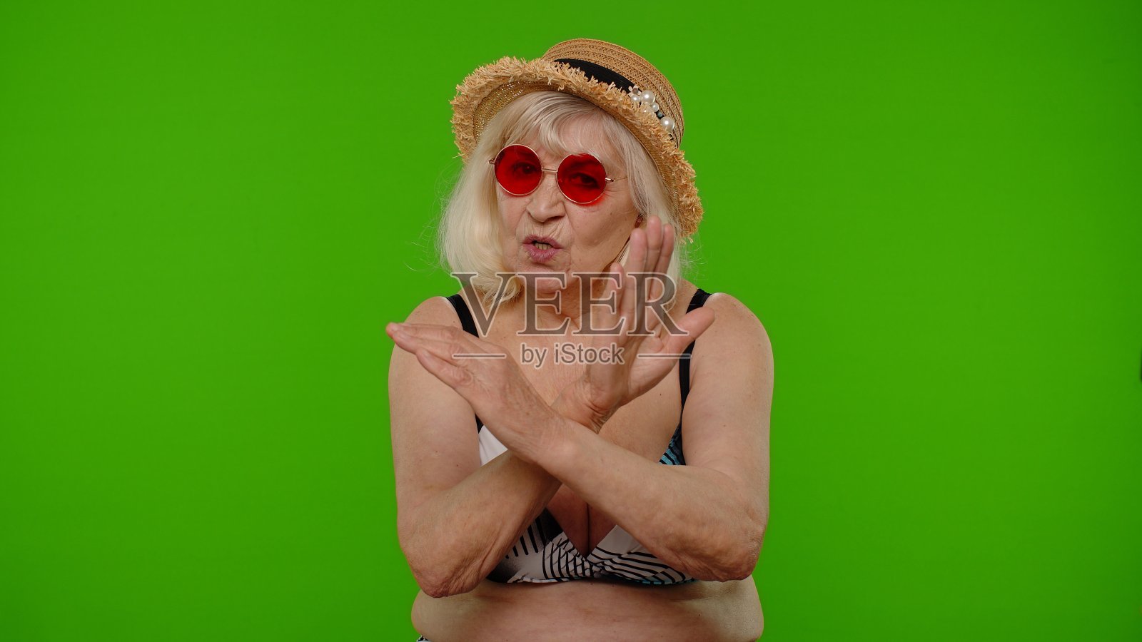 戴红色太阳镜的中年妇女游客展示停止标志照片摄影图片