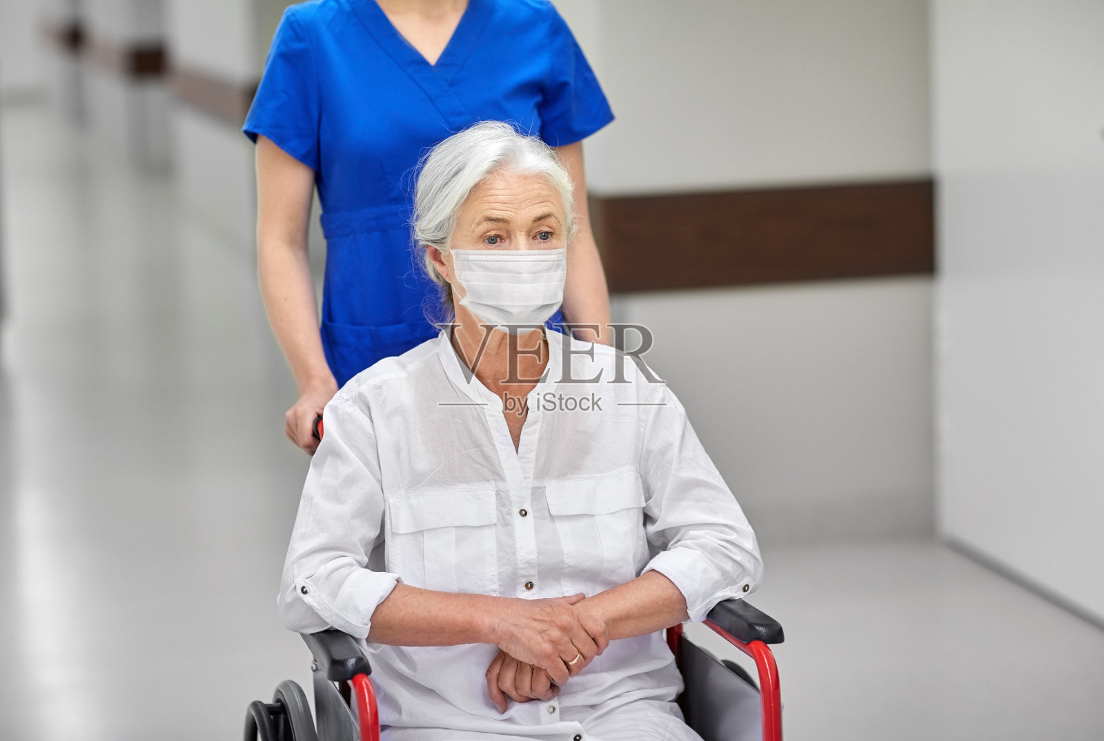 医院里戴着面具坐在轮椅上的老年妇女照片摄影图片