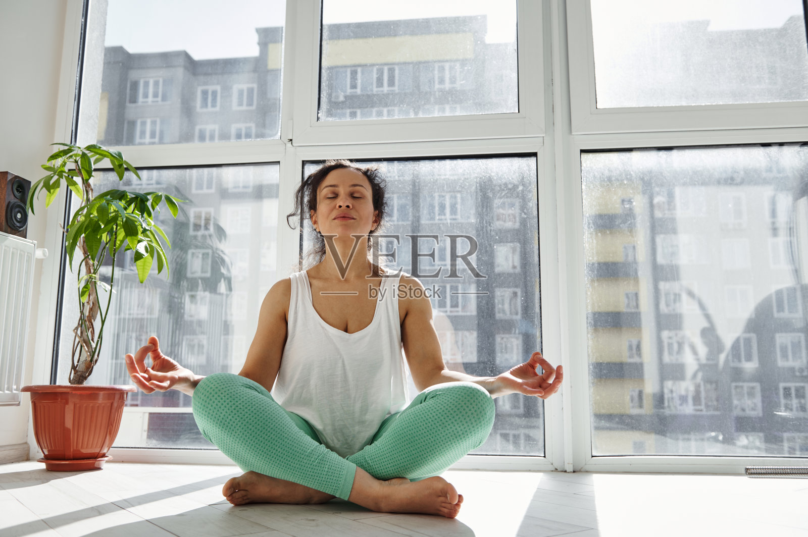 年轻的非洲裔美国妇女坐在莲花姿势与手在阿哈姆卡拉mudra。在家冥想的女人照片摄影图片