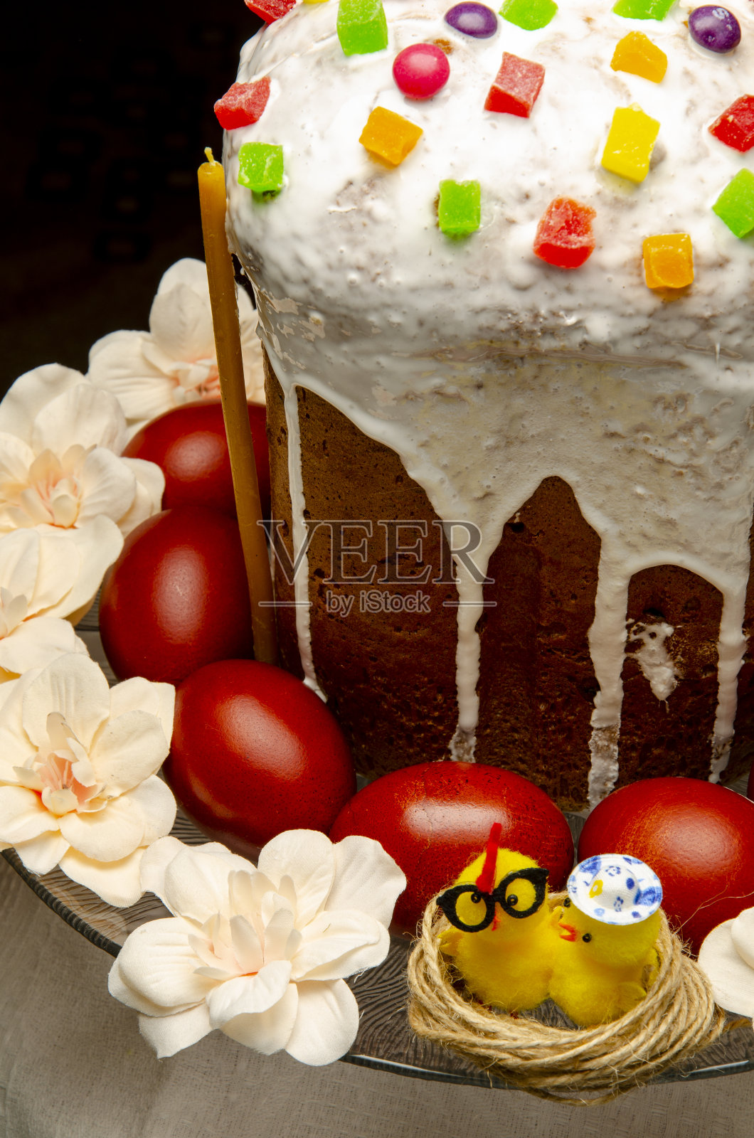 复活节蛋糕和彩蛋在盘子里，前景是花照片摄影图片