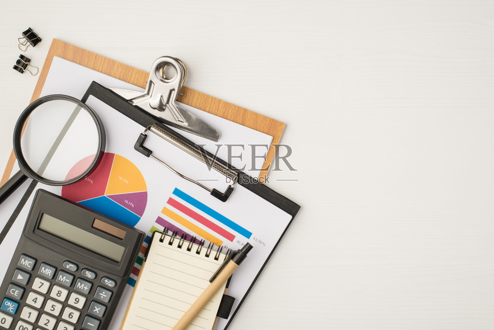 顶视图照片的商业工作场所与两个文件夹饼图，图表，活页夹，放大镜，玻璃，计算器，笔记本和钢笔，在孤立的白色背景与拷贝空间照片摄影图片