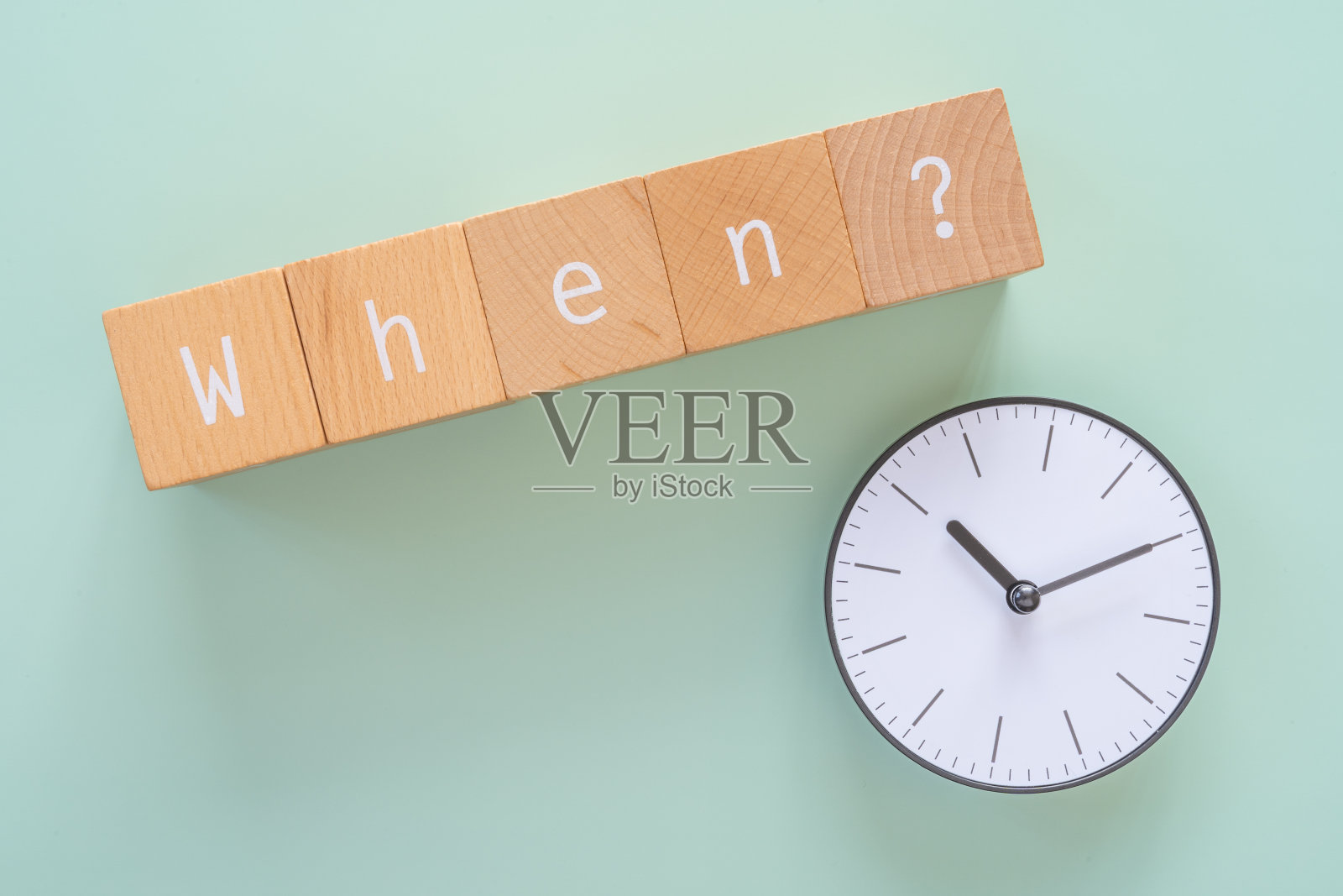 什么时候?;五个带有“何时?”文本的木块和一个时钟。照片摄影图片
