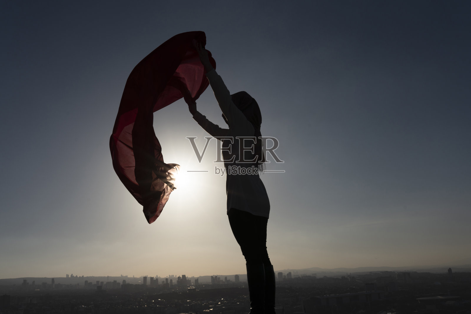 一个披着红披肩的女人的剪影照片摄影图片