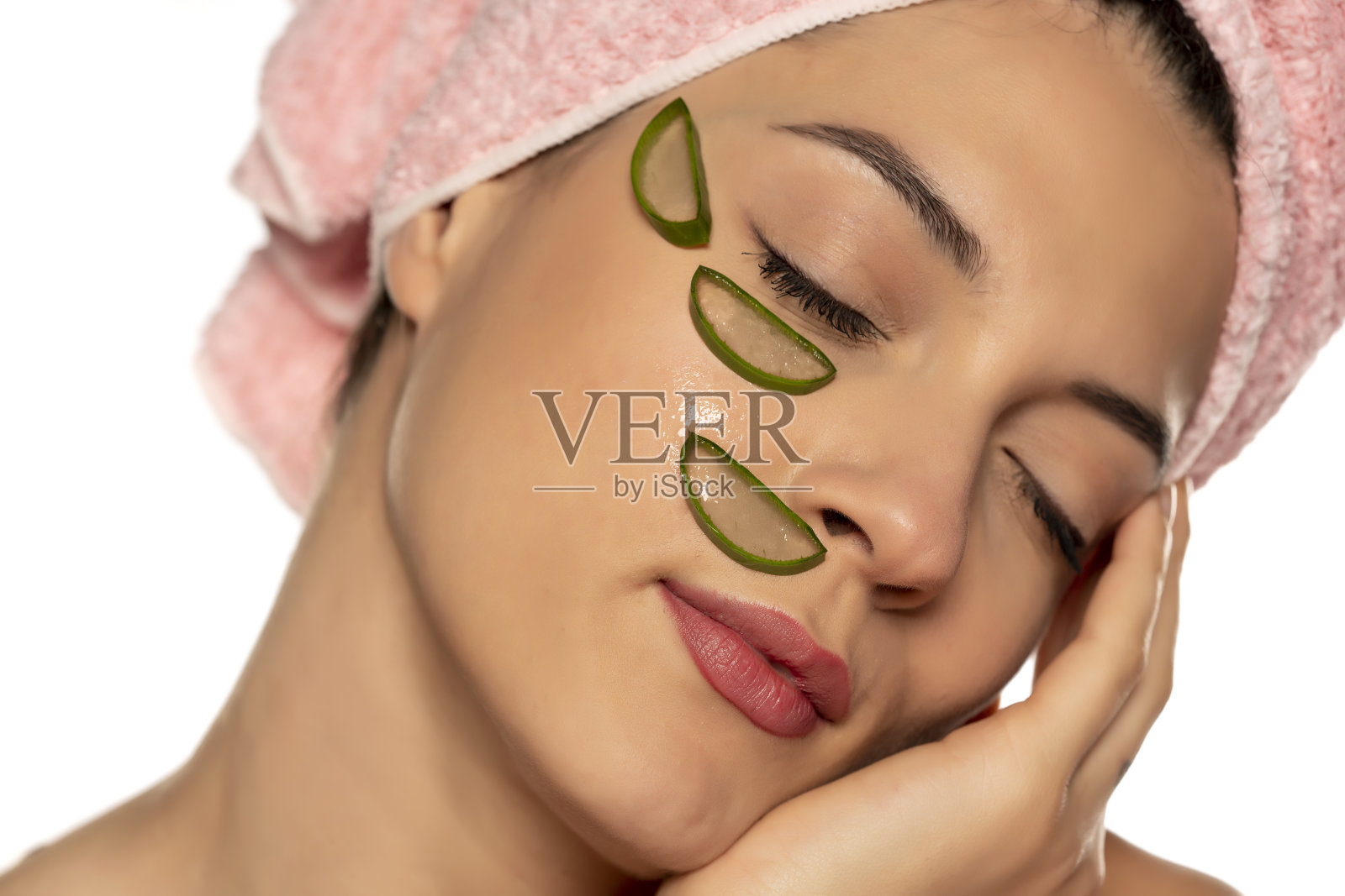年轻美丽的女人摆姿势与芦荟片在她的脸上照片摄影图片