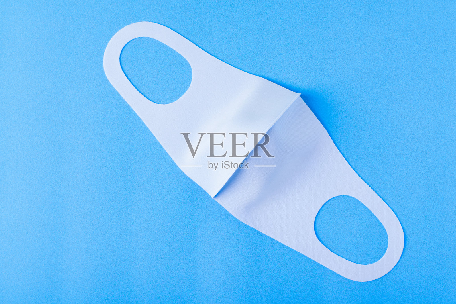 蓝色的面具，柔软的织物上彩色的背景照片摄影图片