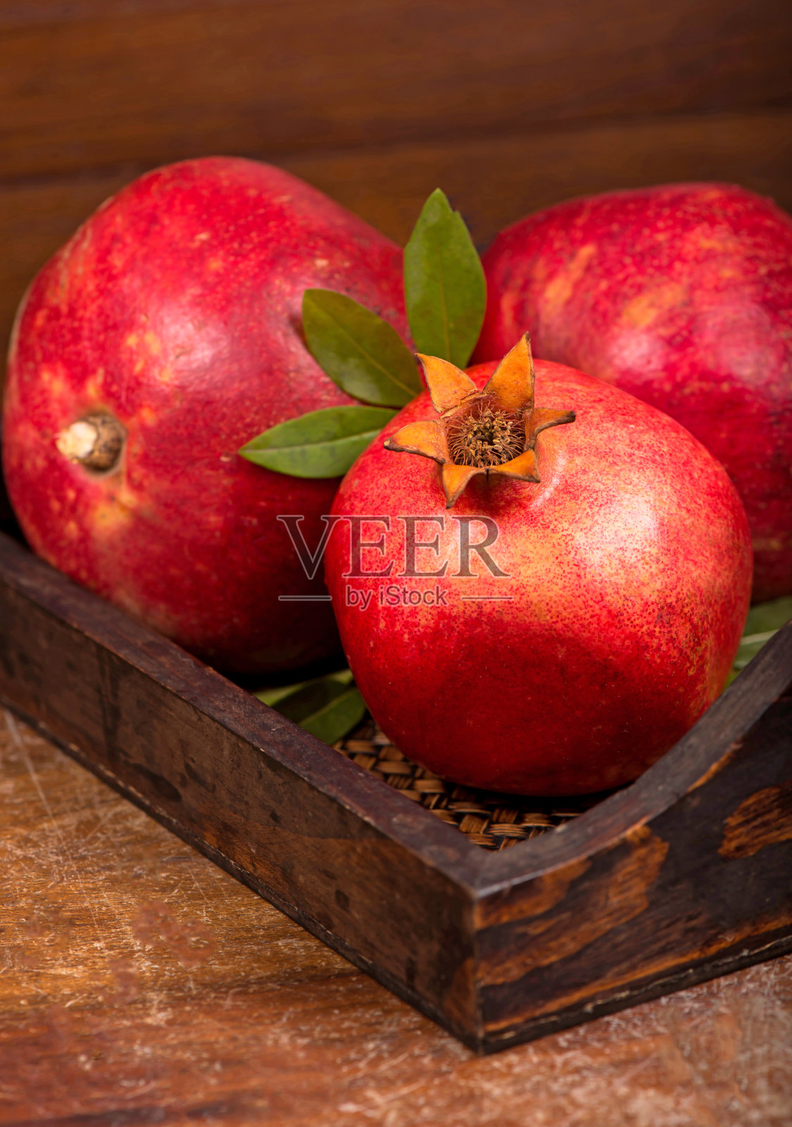 木质背景上是成熟的石榴果实照片摄影图片