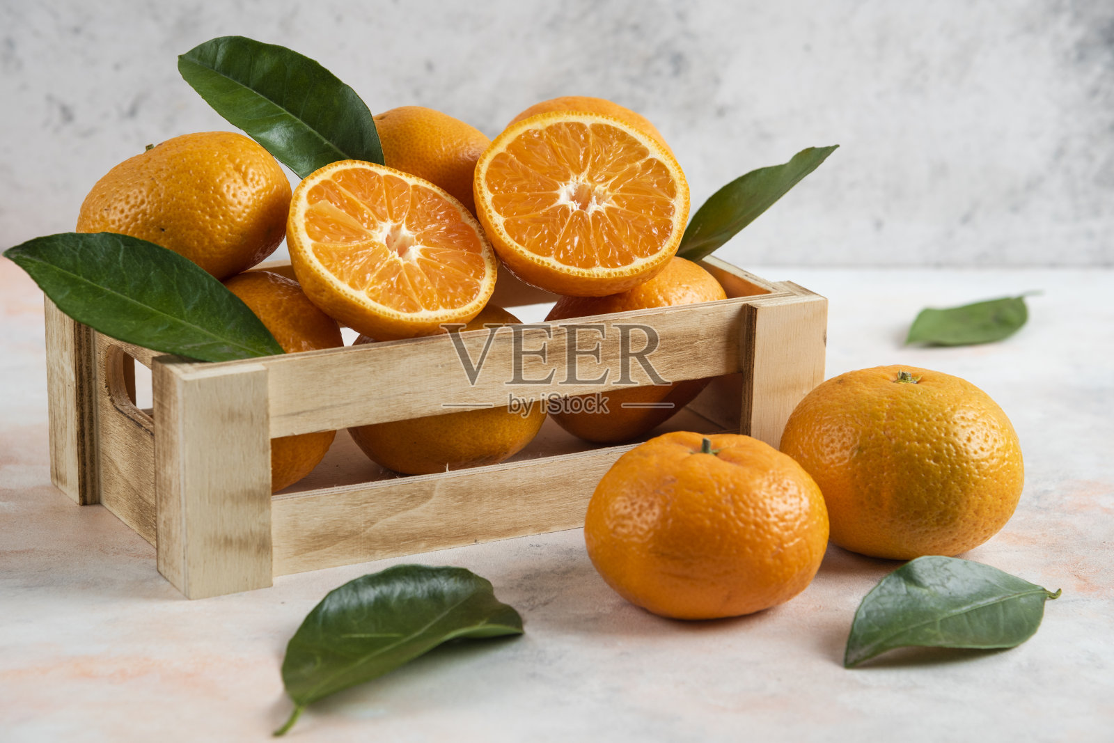 木盒里新鲜多汁的小柑橘的特写照片。全切或半切照片摄影图片