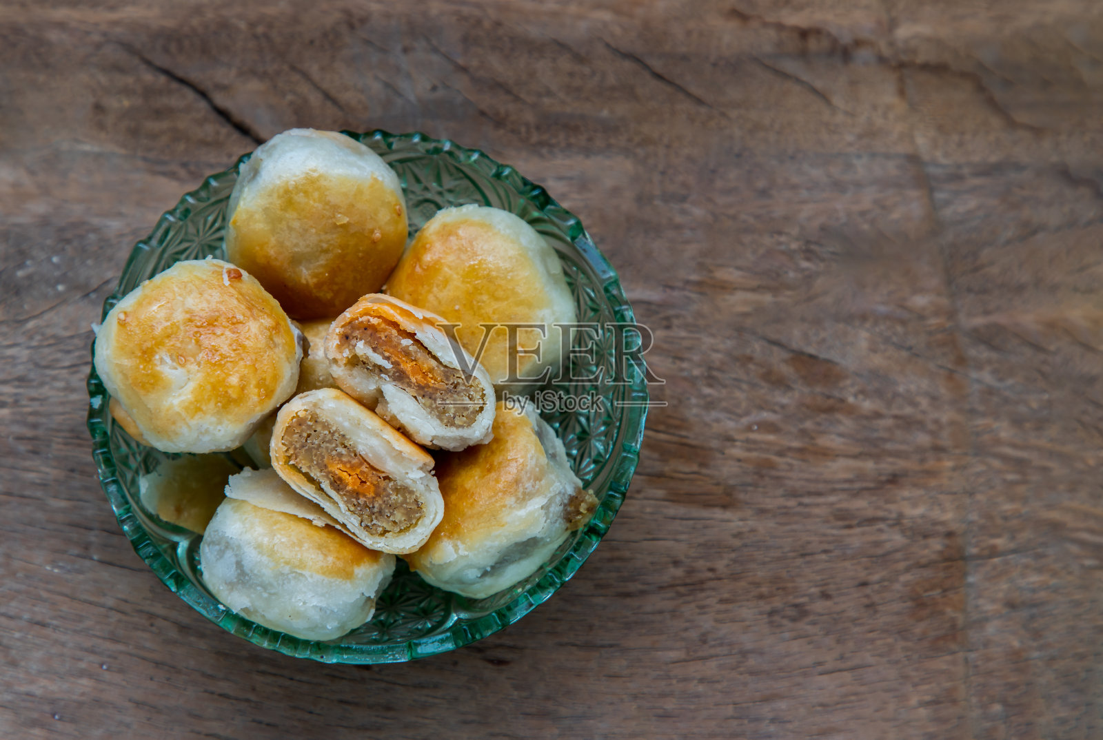 传统的亚洲糕点或道索尔在质朴的木桌上。绿豆沙、芋头和咸蛋馅的中式甜糕点。照片摄影图片