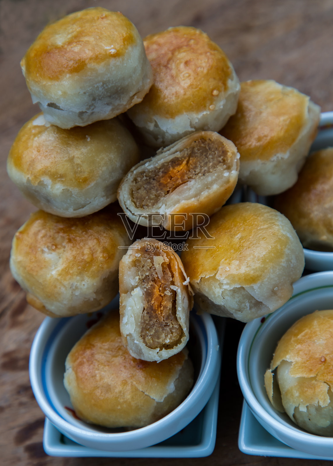 传统的亚洲糕点或道索尔在质朴的木桌上。绿豆沙、芋头和咸蛋馅的中式甜糕点。照片摄影图片