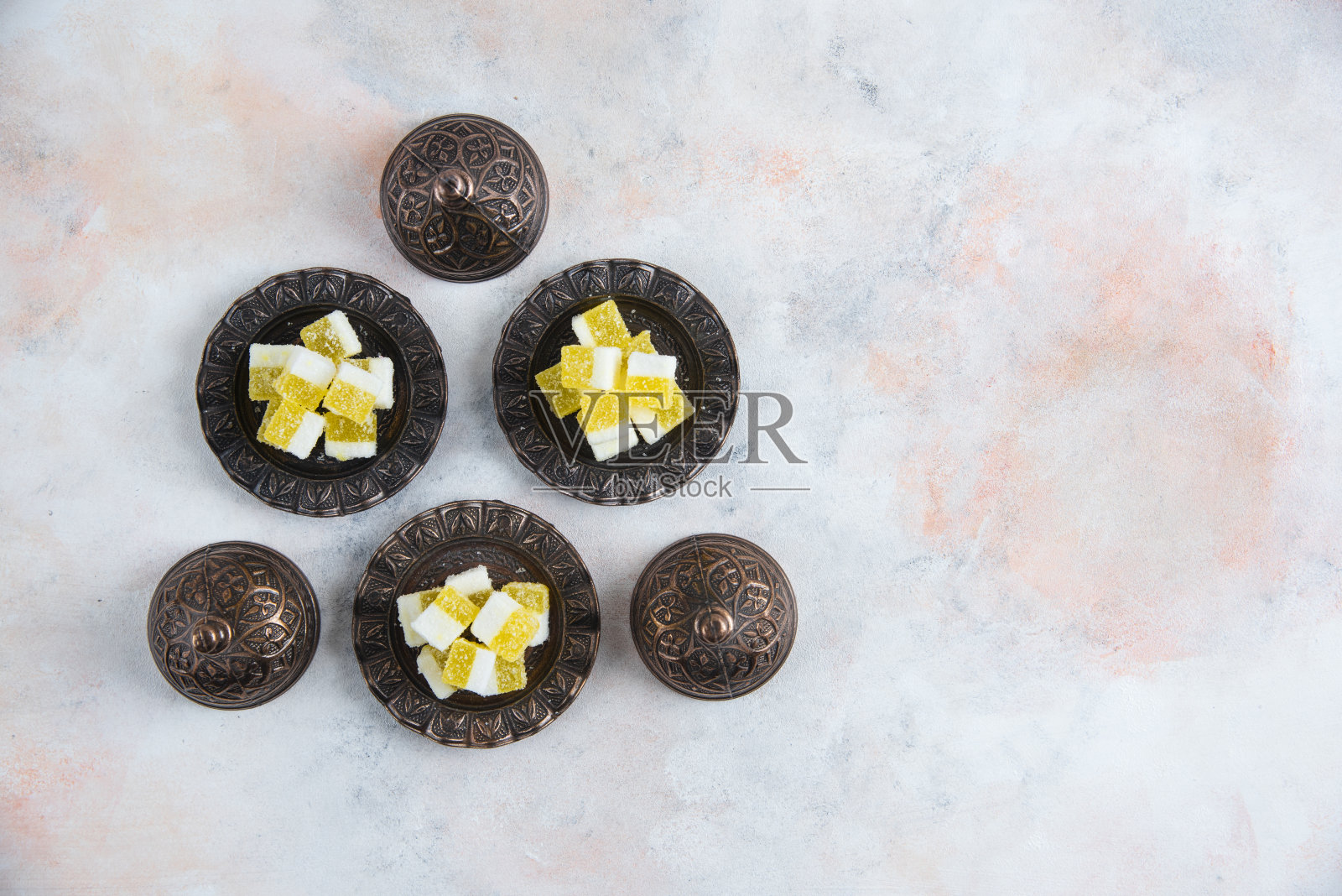 白色背景的陶器上放着黄色糖果照片摄影图片