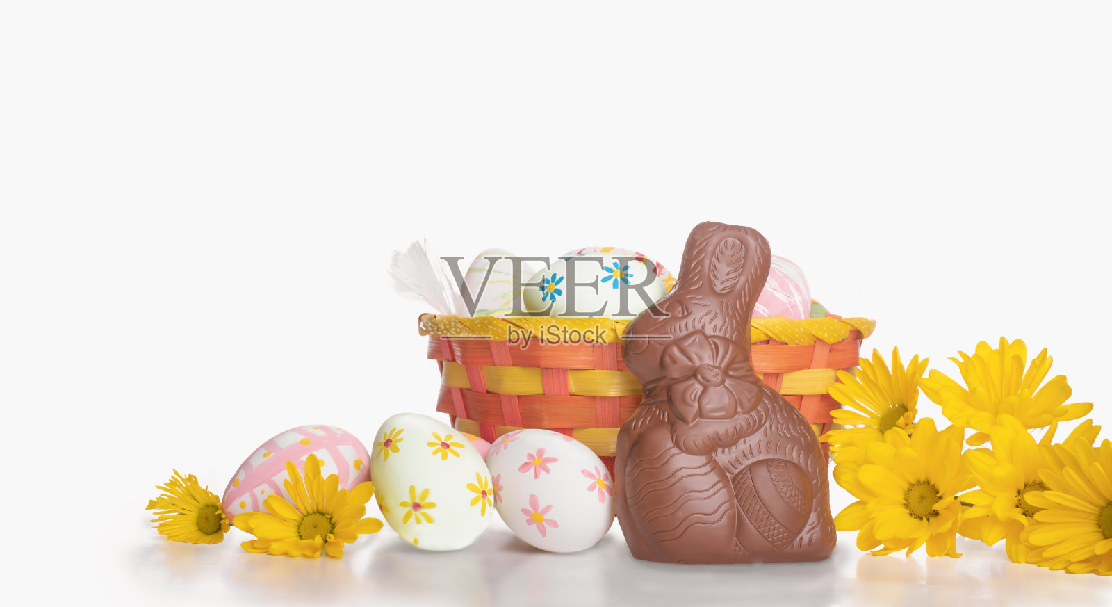 复活节篮子与鲜花，鸡蛋和可爱的兔子孤立在白色的背景照片摄影图片