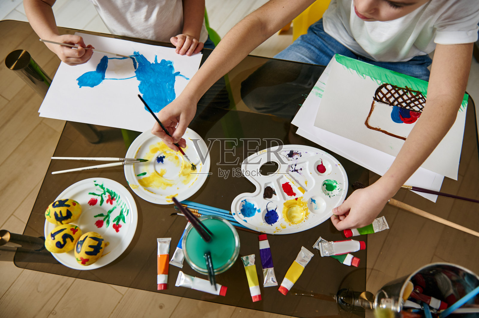 孩子们用水彩颜料在纸上作画照片摄影图片