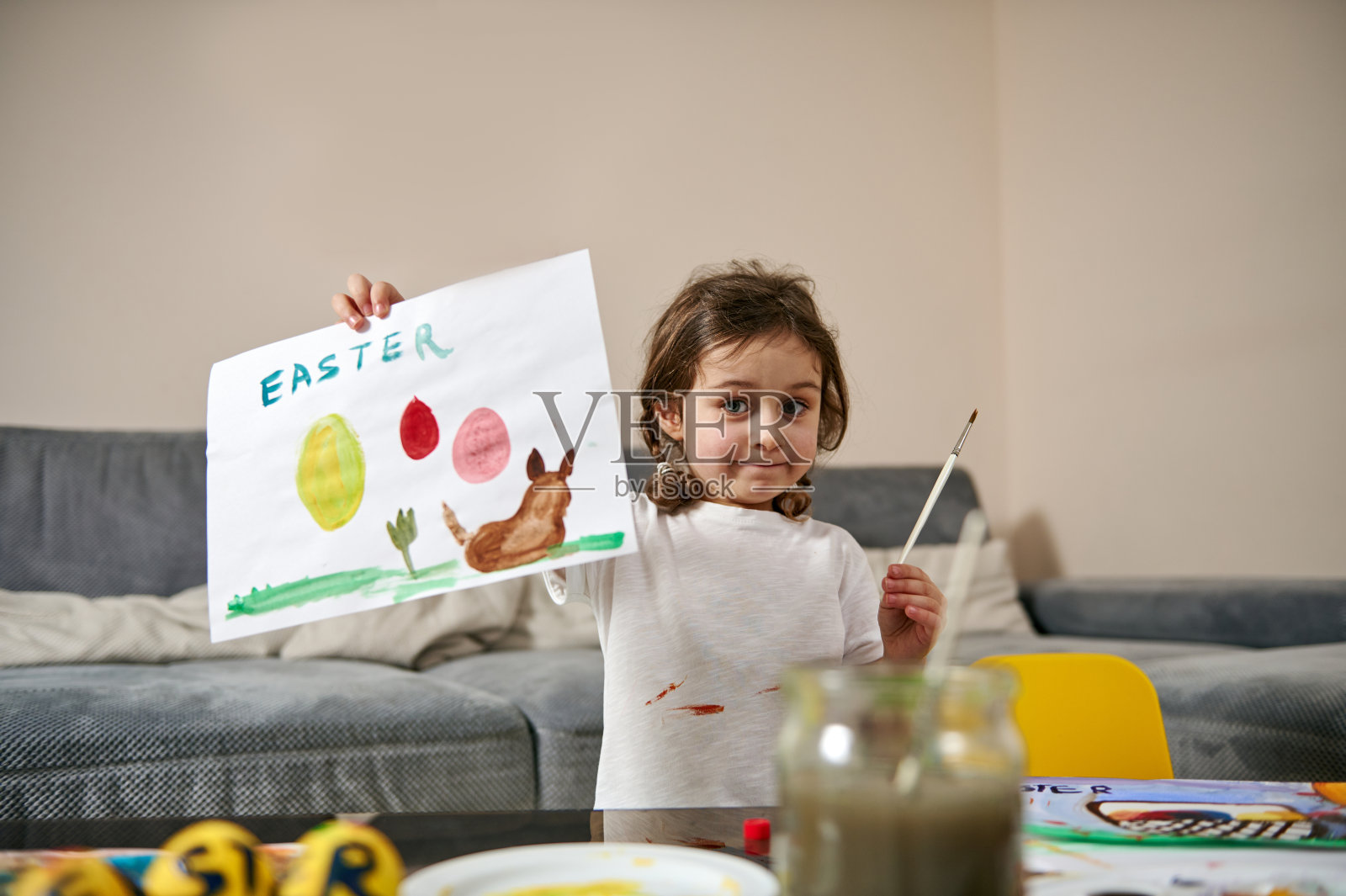 一个快乐的小女孩向镜头展示她美丽的图画，复活节主题，水彩技法照片摄影图片