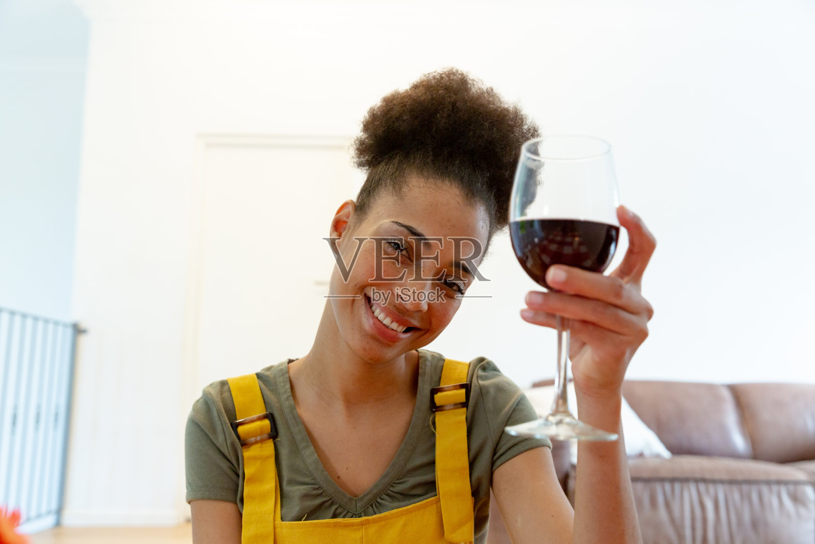 混血女人喝着酒在家微笑照片摄影图片