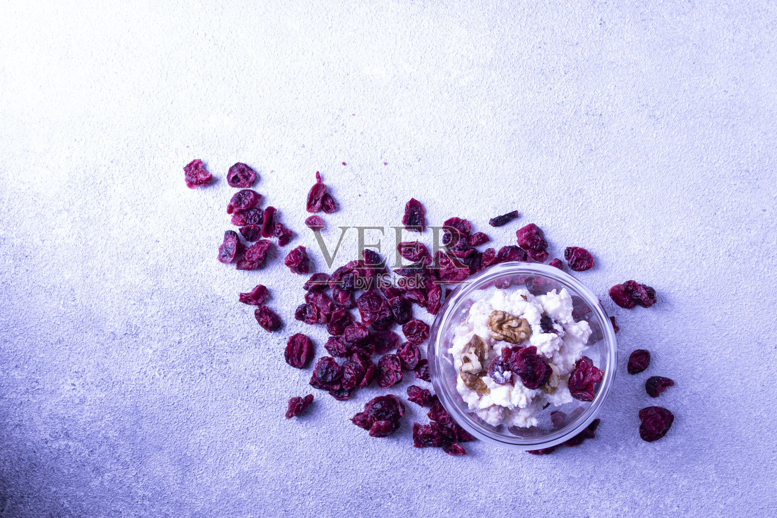 甜点是白软干酪、浆果、玻璃杯里的核桃、散放的晒干的樱桃。在白色的石膏。副本的空间。照片摄影图片