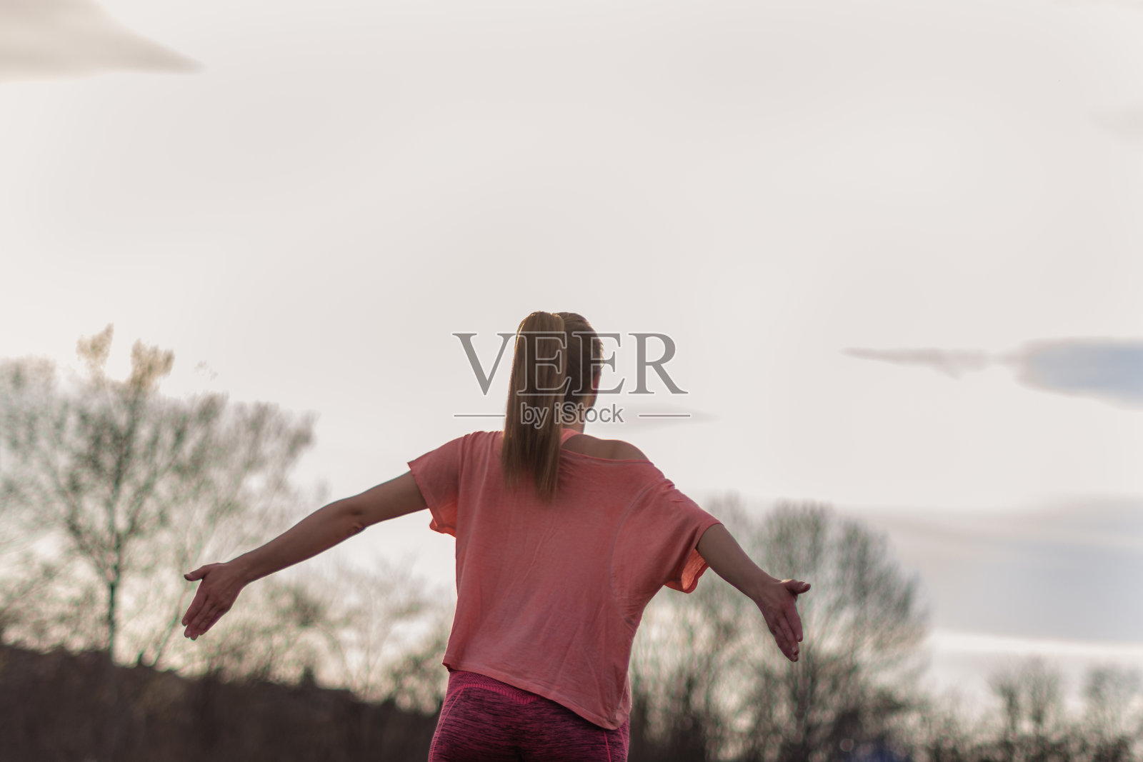 一个女人伸开双臂的背影照片摄影图片