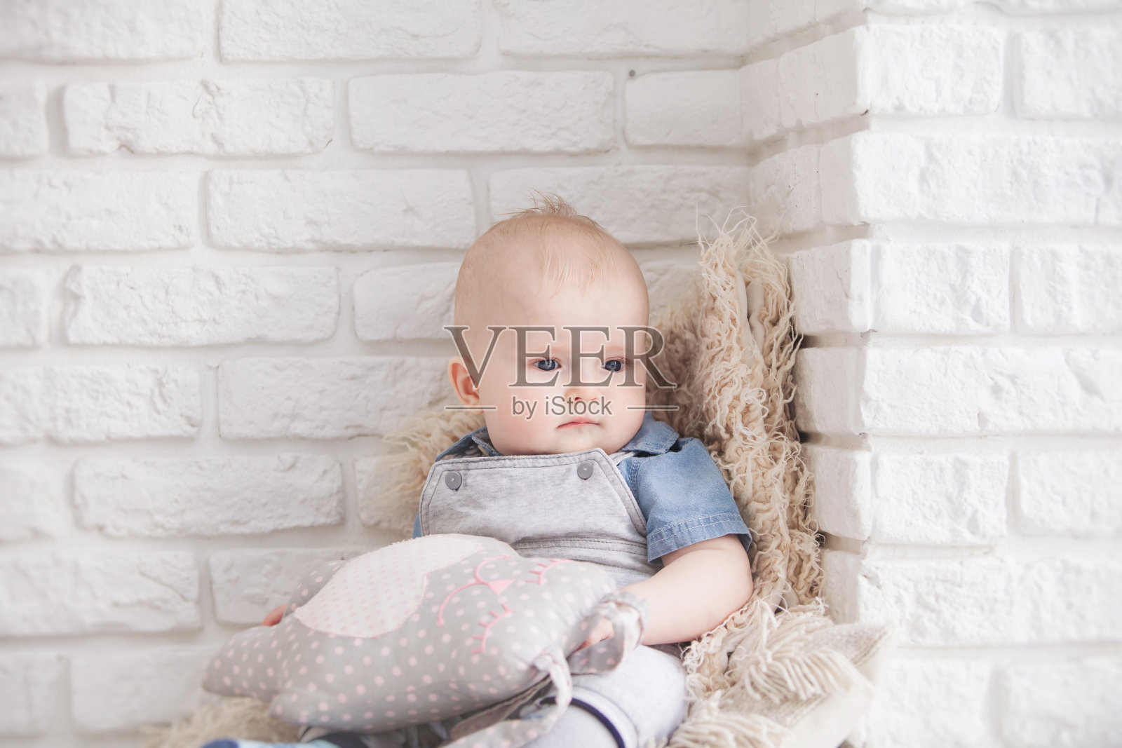 小男孩坐在窗边的地板上照片摄影图片