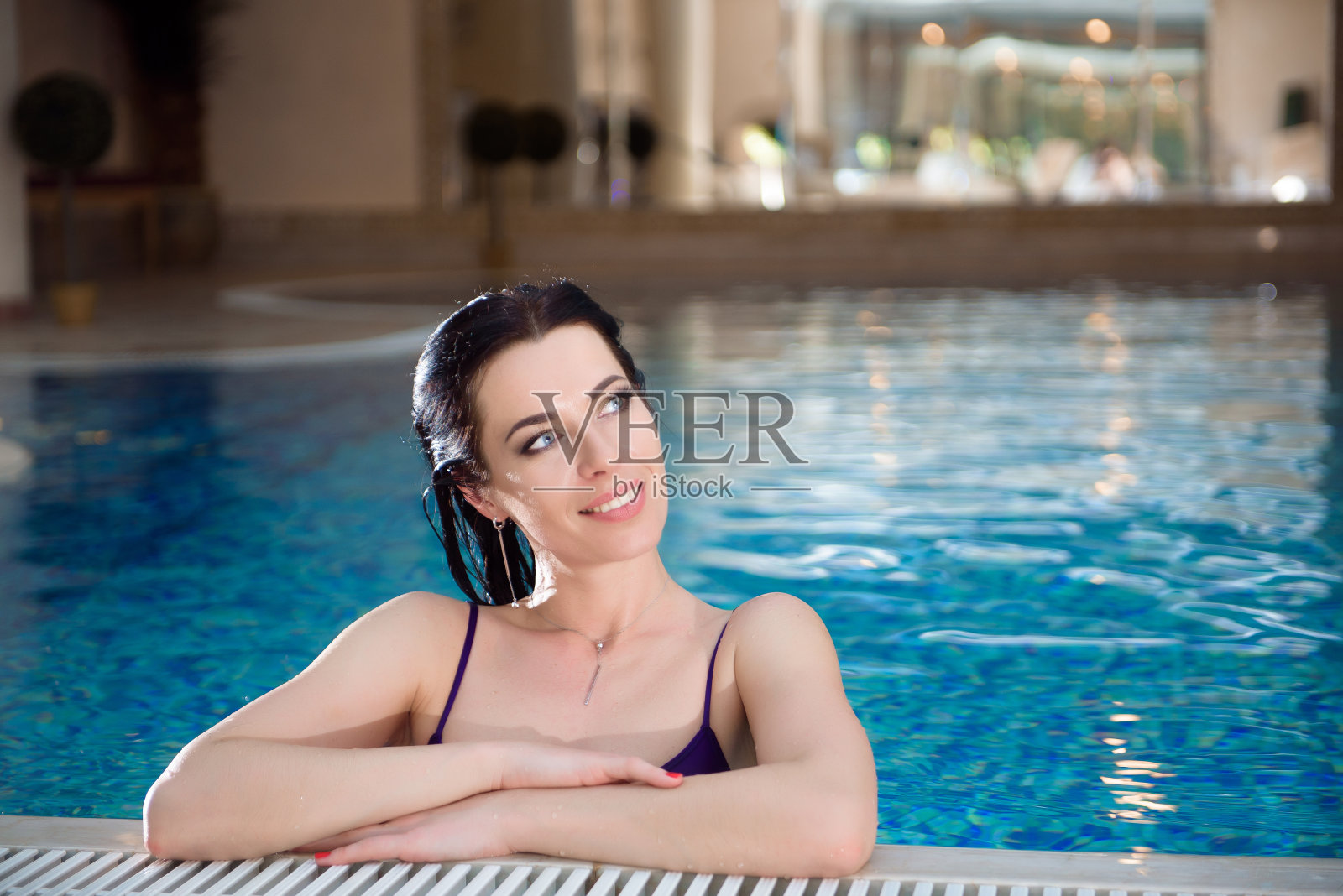 可爱的女孩正在游泳池里放松。放松池温泉。照片摄影图片