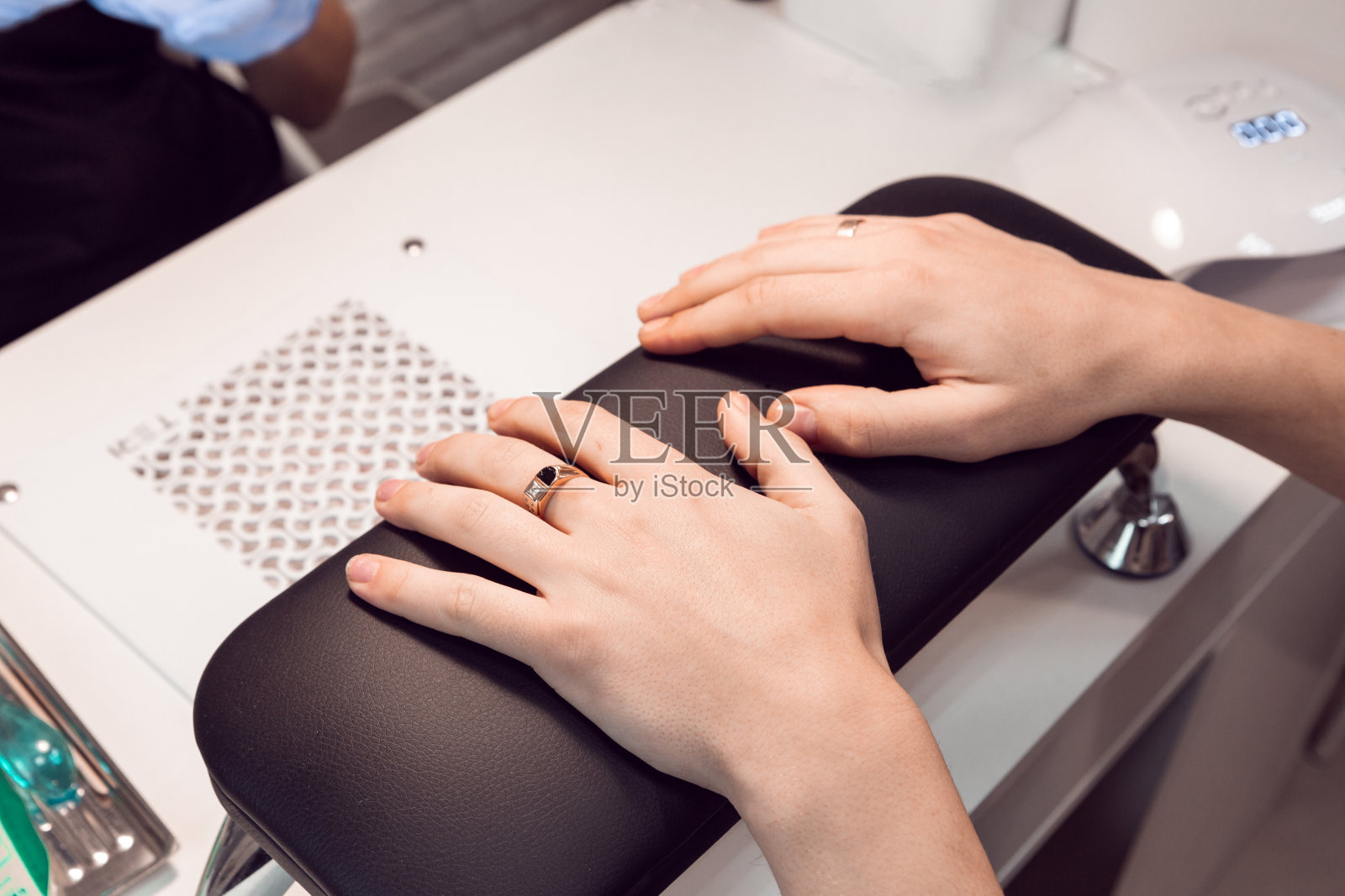 一个男人在美容院，正在修指甲。男性双手前的五金美甲程序。男人的修指甲。照片摄影图片