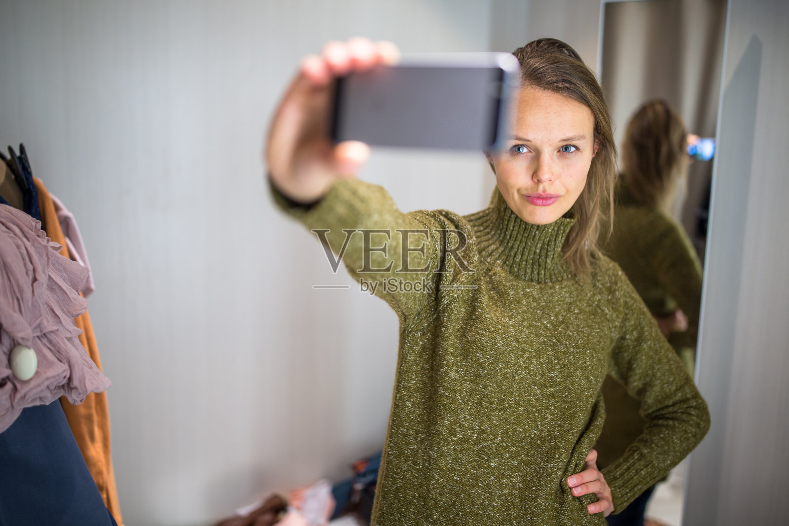 一名年轻女子在一家时装店购物，正在试穿一些衣服照片摄影图片