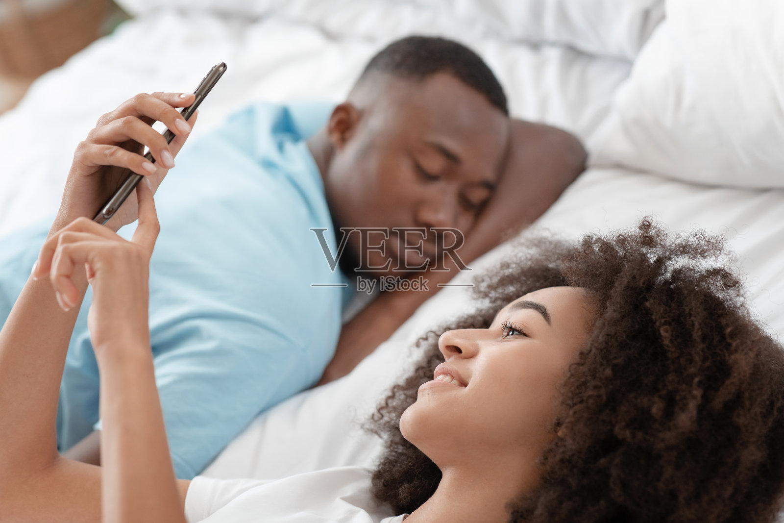 放松，休息，早上醒来时床上有电子设备照片摄影图片