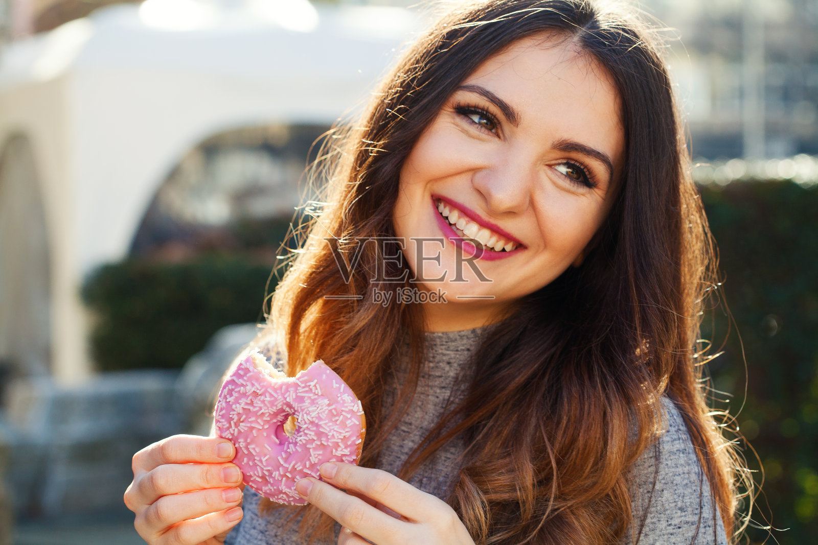 年轻女子在吃甜甜圈照片摄影图片