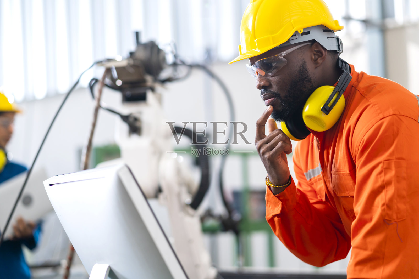 肖像的美国工程师技术员穿着安全制服手控制自动化机器人手臂焊机与笔记本工业4.0工厂背景概念照片摄影图片
