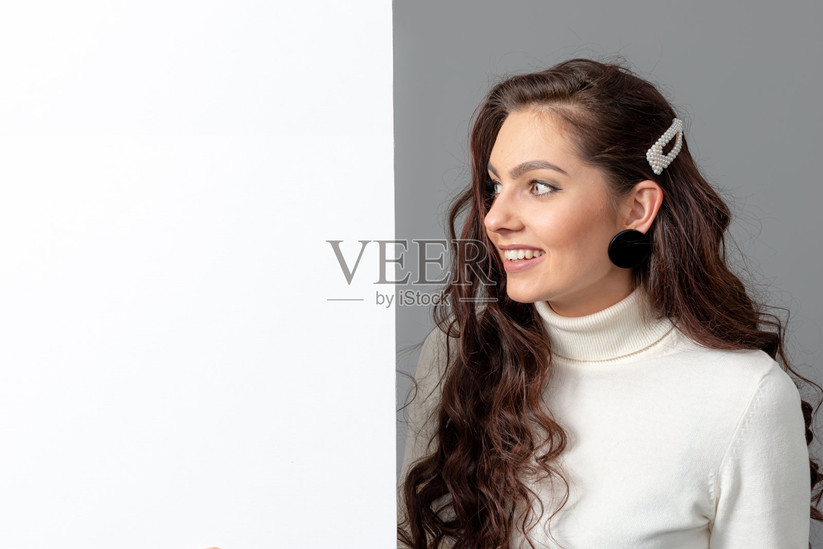 美丽性感的女人长卷发显示一个空白的旗帜，孤立在灰色，复制空间照片摄影图片