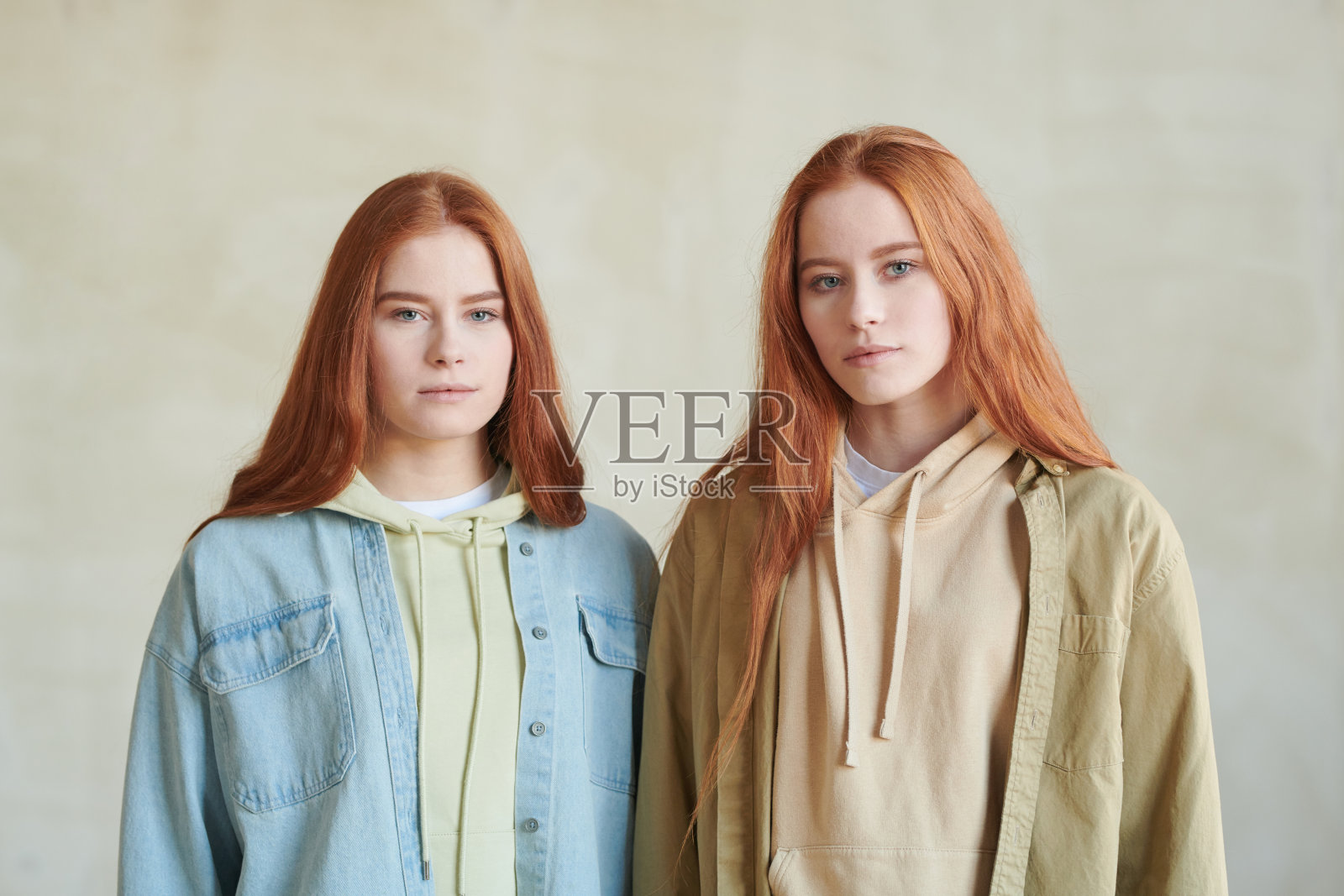 水平媒体工作室肖像两个美丽的年轻卡高加索双胞胎姐妹站在一起看着相机照片摄影图片