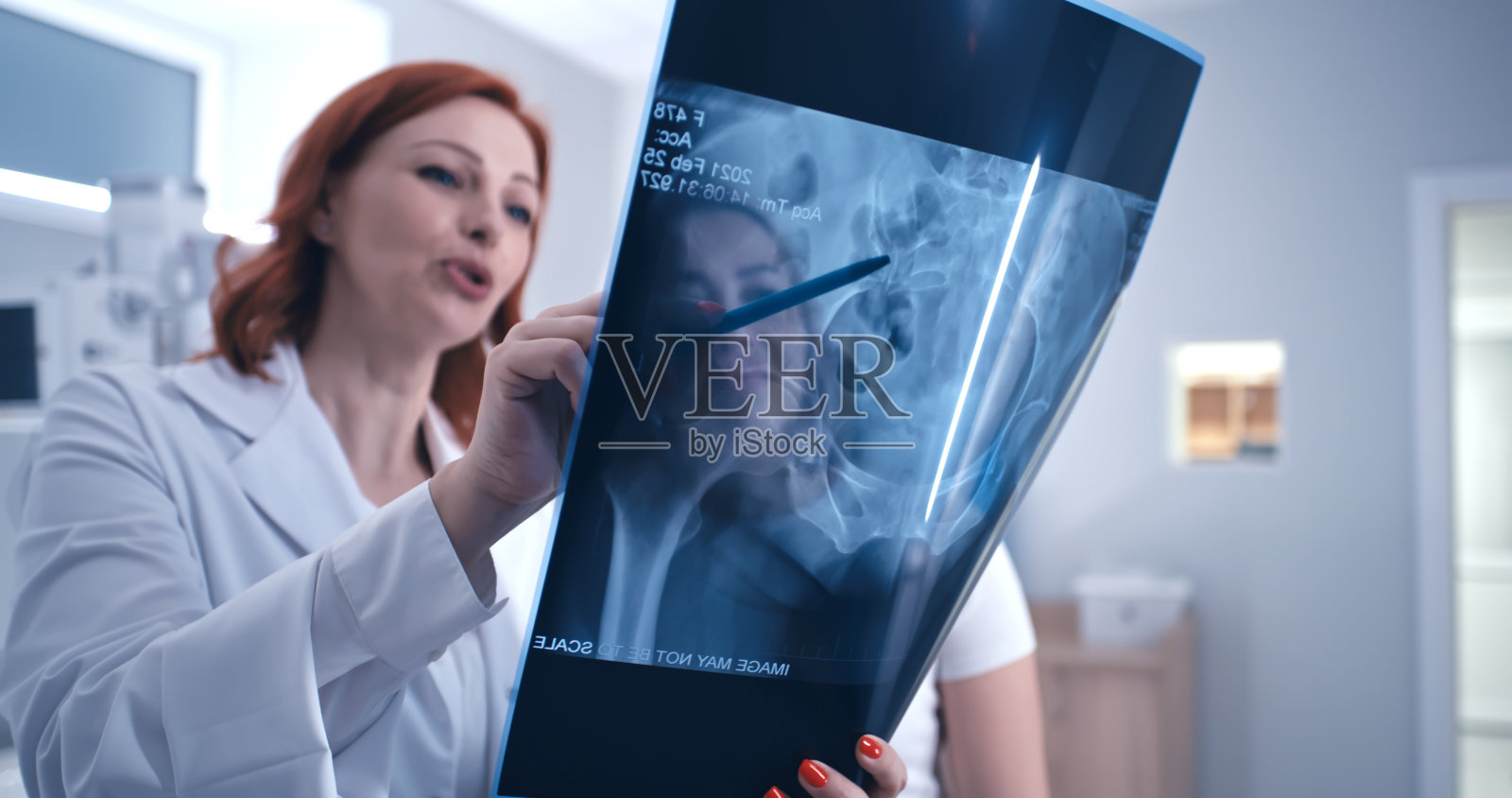 成熟的医生向病人展示有希望的X光结果照片摄影图片