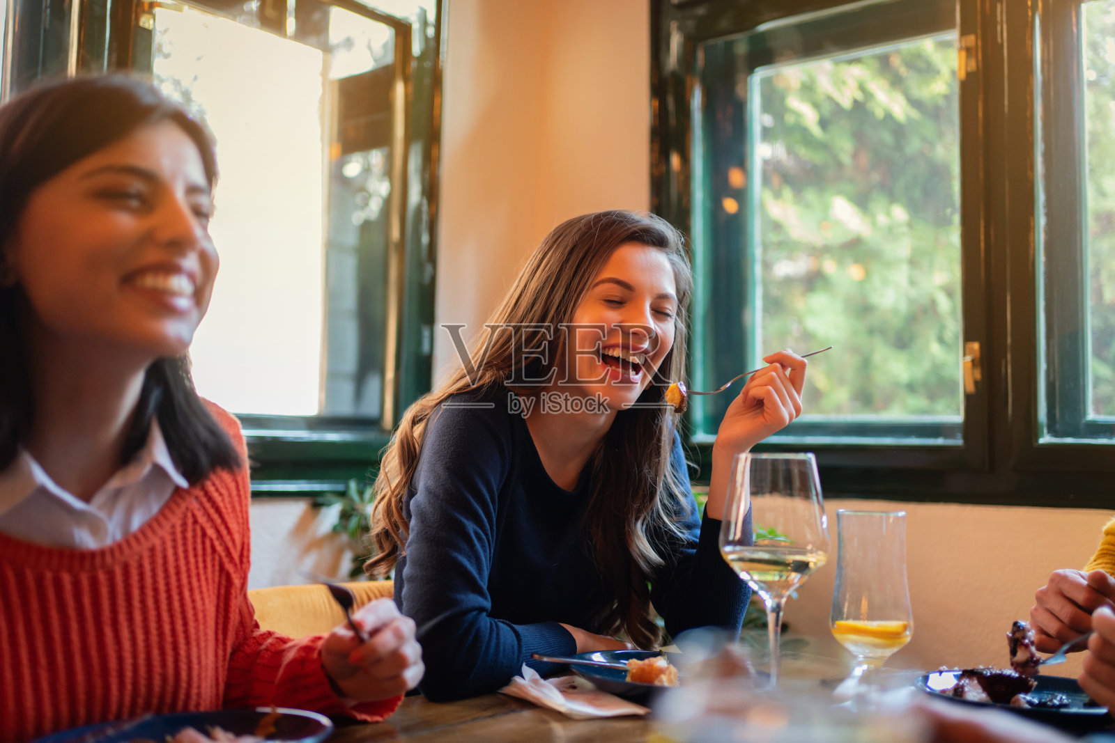 快乐的女友在餐厅用餐照片摄影图片