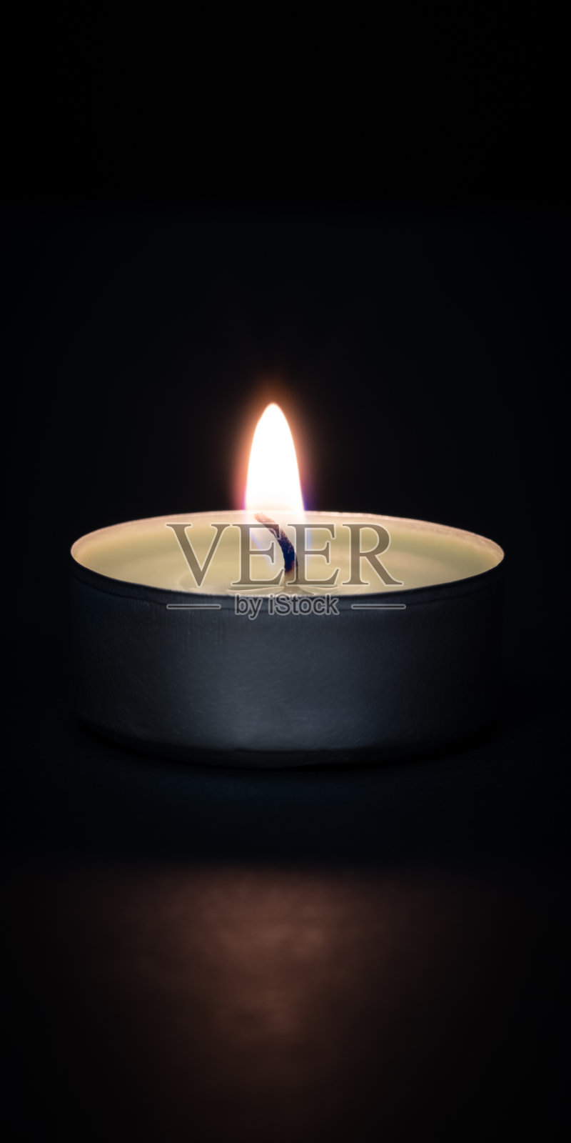 在黑暗背景上燃烧着的蜡烛，前景中有火光。照片摄影图片