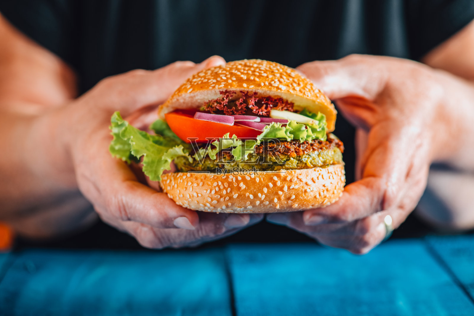 拿着炸丸子汉堡照片摄影图片