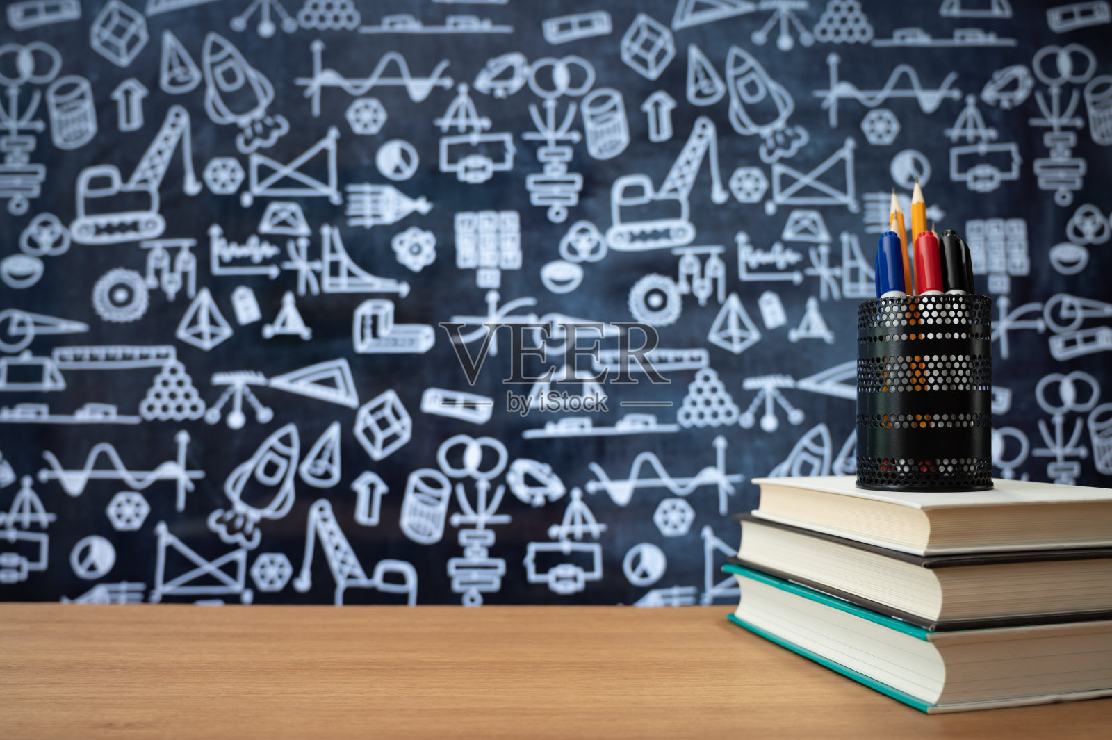 黑板与手绘数学相关的图标。书堆放在书桌上。教育的概念。照片摄影图片