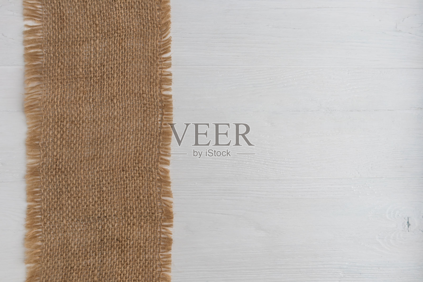 粗糙的亚麻餐巾在白色的木制背景与文字空间。布局。照片摄影图片