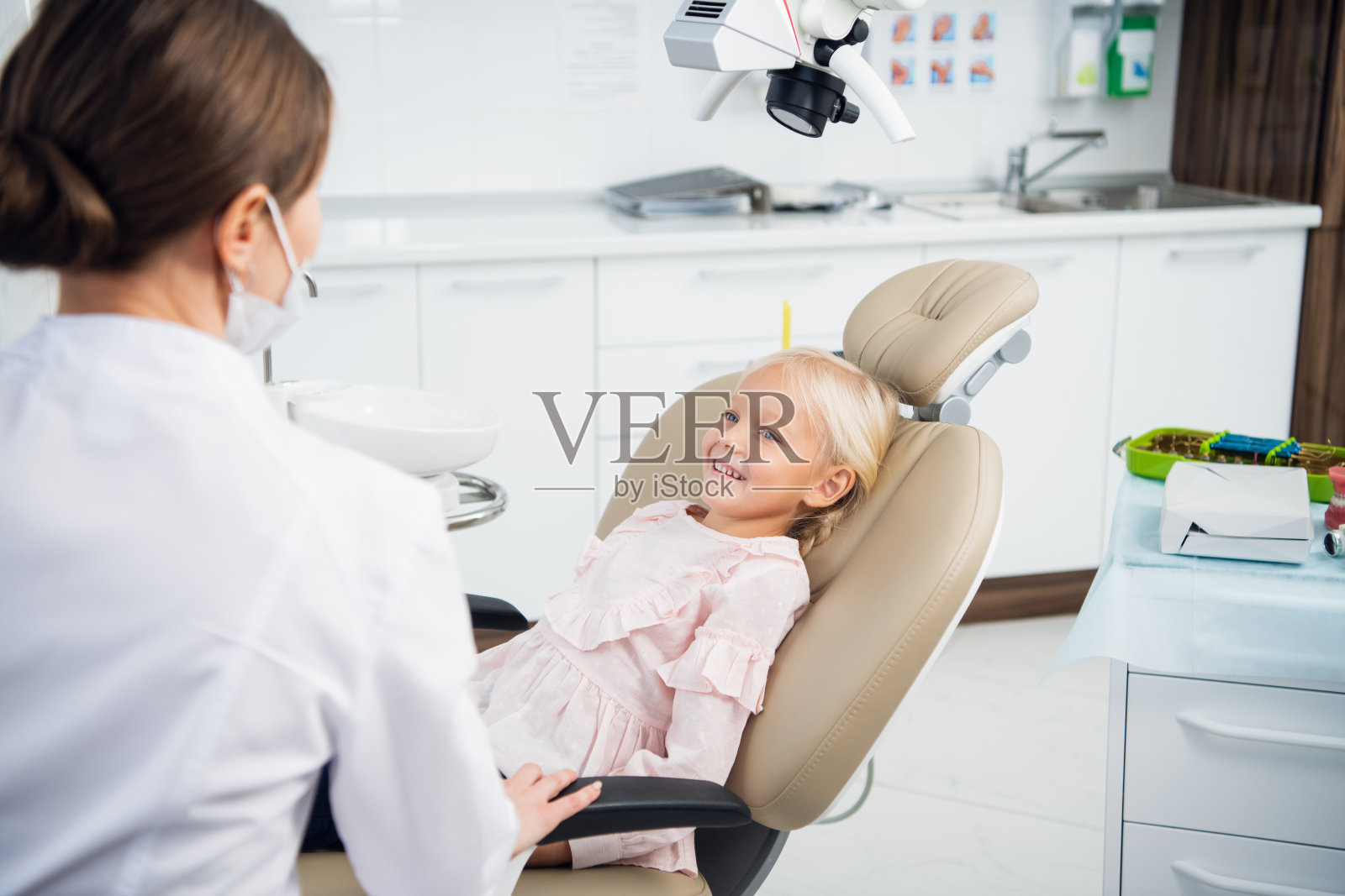 一位年轻的女牙医正在为她的病人进行全面的牙齿检查照片摄影图片