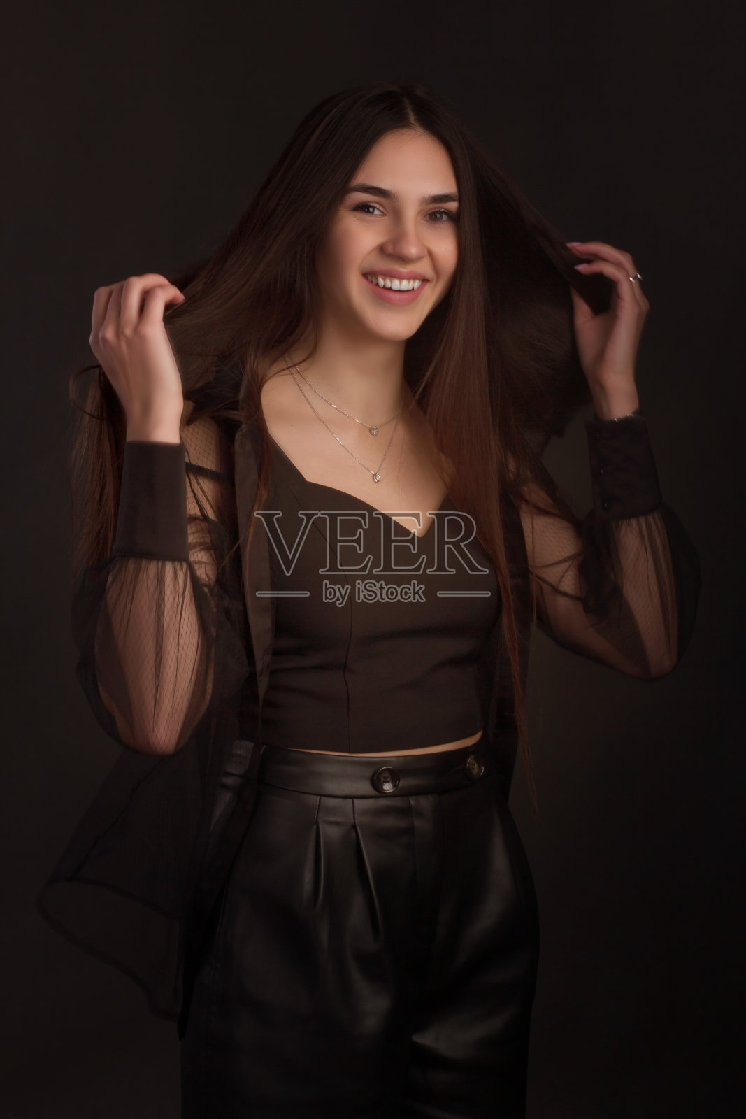 一个留着棕色长发的年轻女子的肖像。照片摄影图片