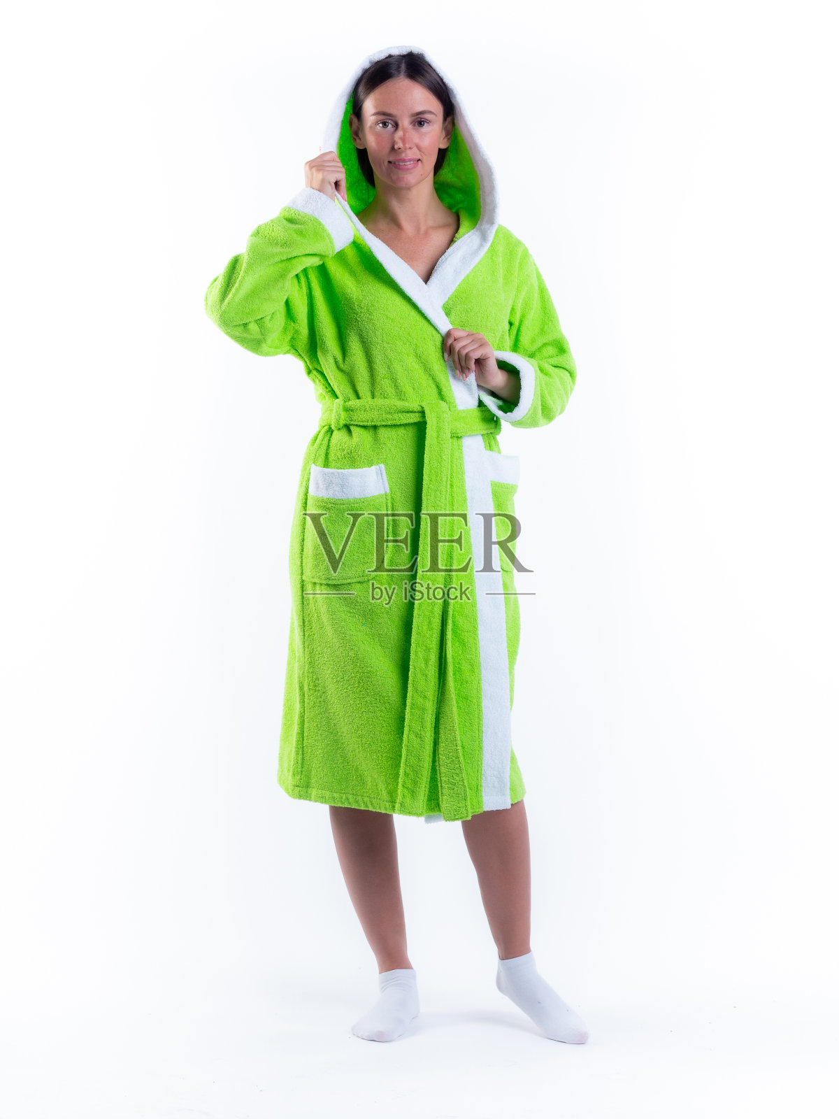 在孤立的白色背景上穿着浴袍的女人，脸上带着微笑。照片摄影图片