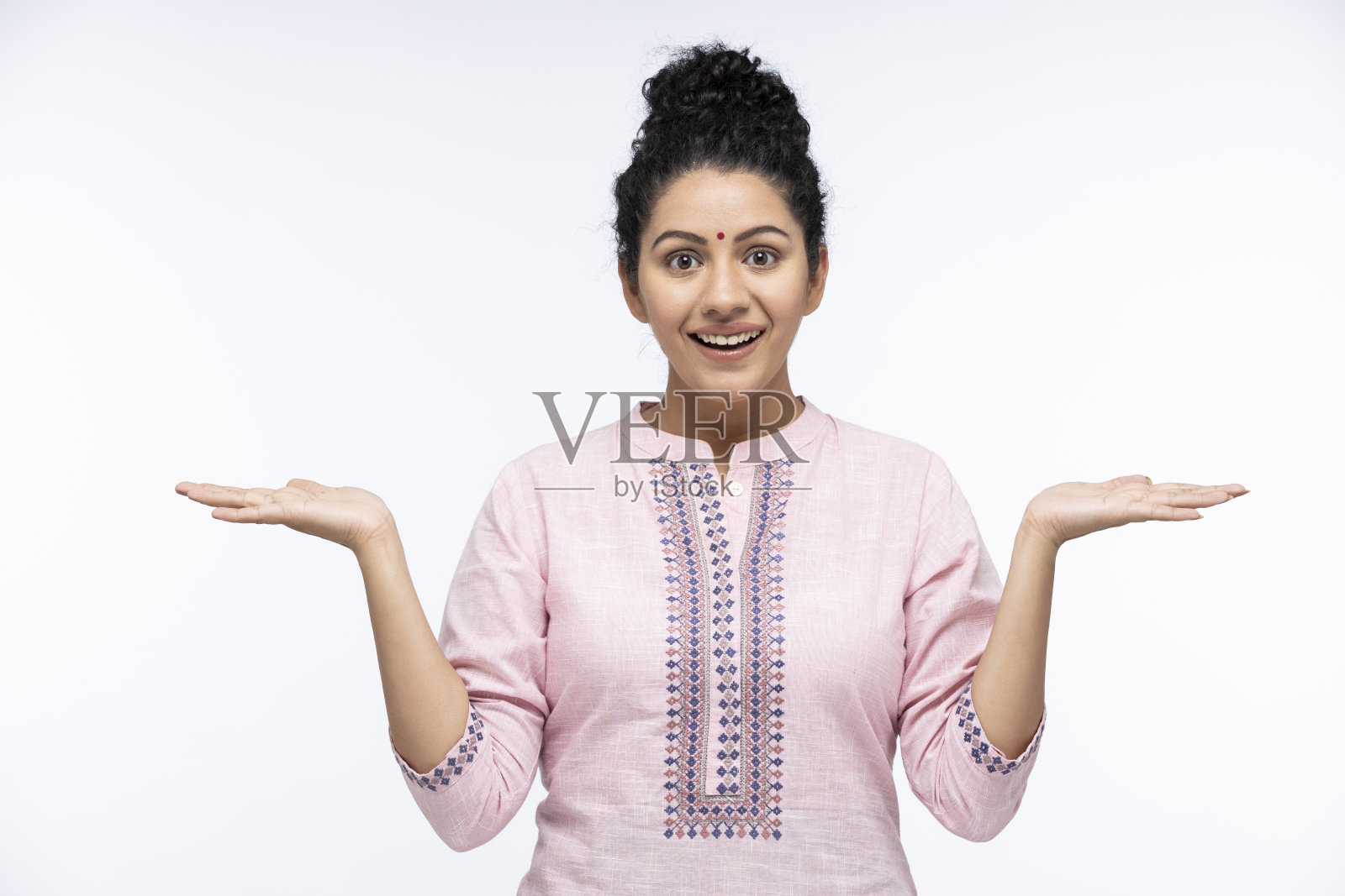 惊讶的女人用手臂打手势，睁大眼睛，嘴巴孤立地看着蓝色背景的相机:-库存照片照片摄影图片