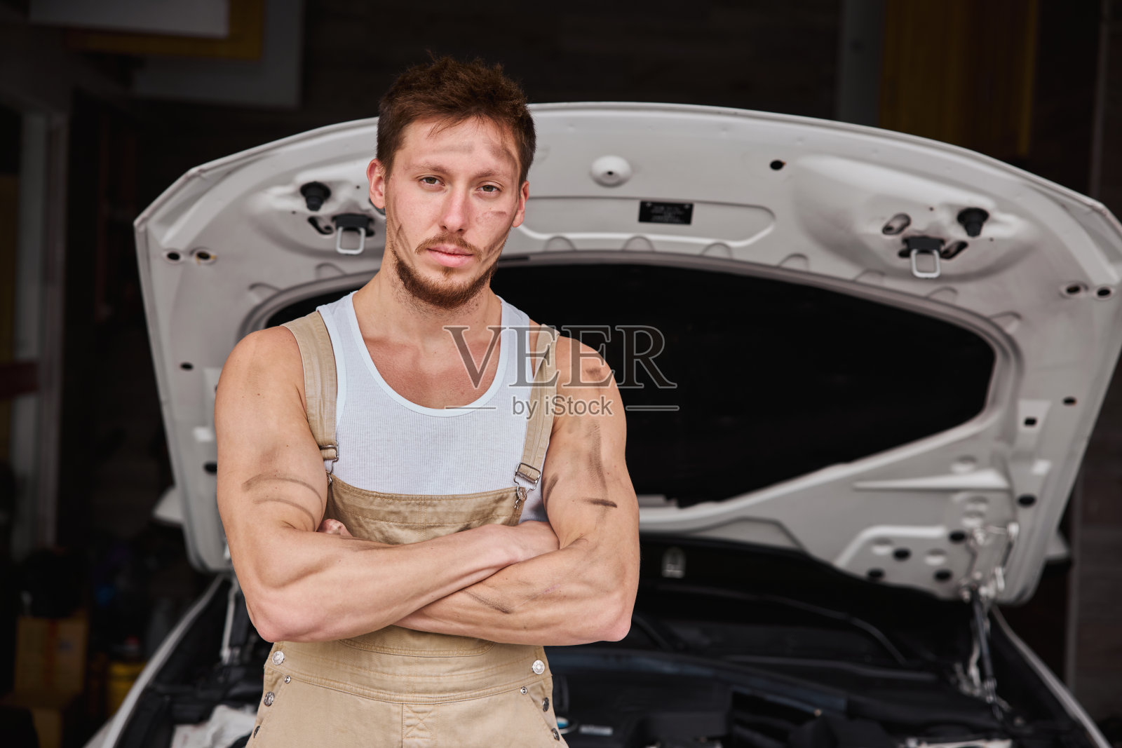 一个修理工在他的车库里工作的肖像照片摄影图片