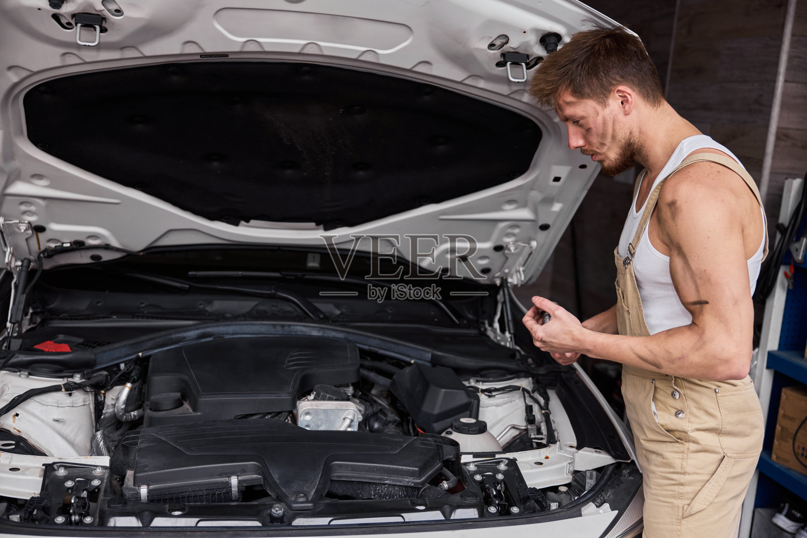 一个修理工在他的车库里工作的肖像。照片摄影图片