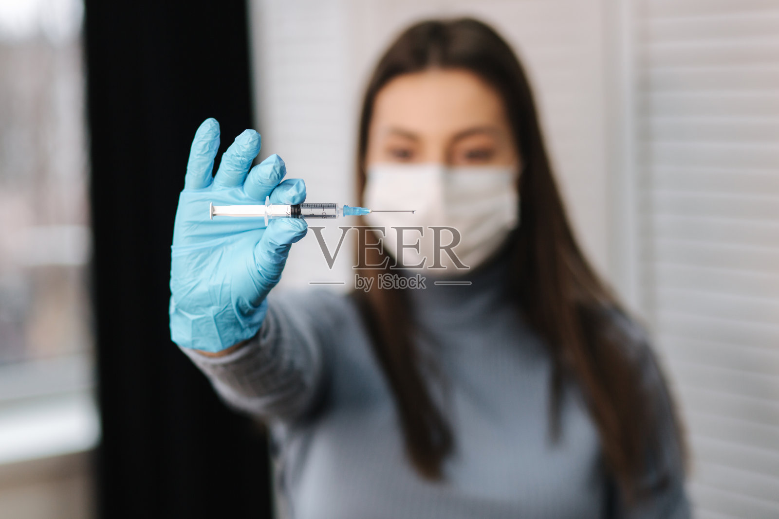 抗击新型冠状病毒的概念。女性拿着装有液体疫苗的注射器照片摄影图片