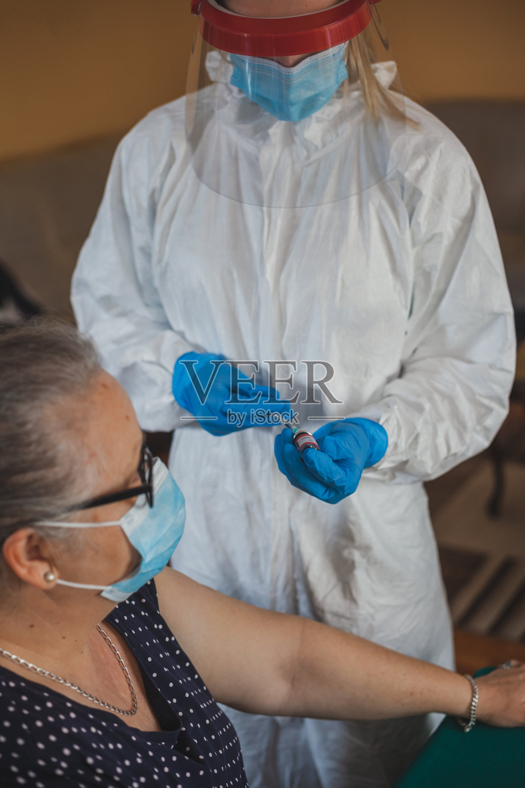 护士在家给老年妇女接种疫苗照片摄影图片