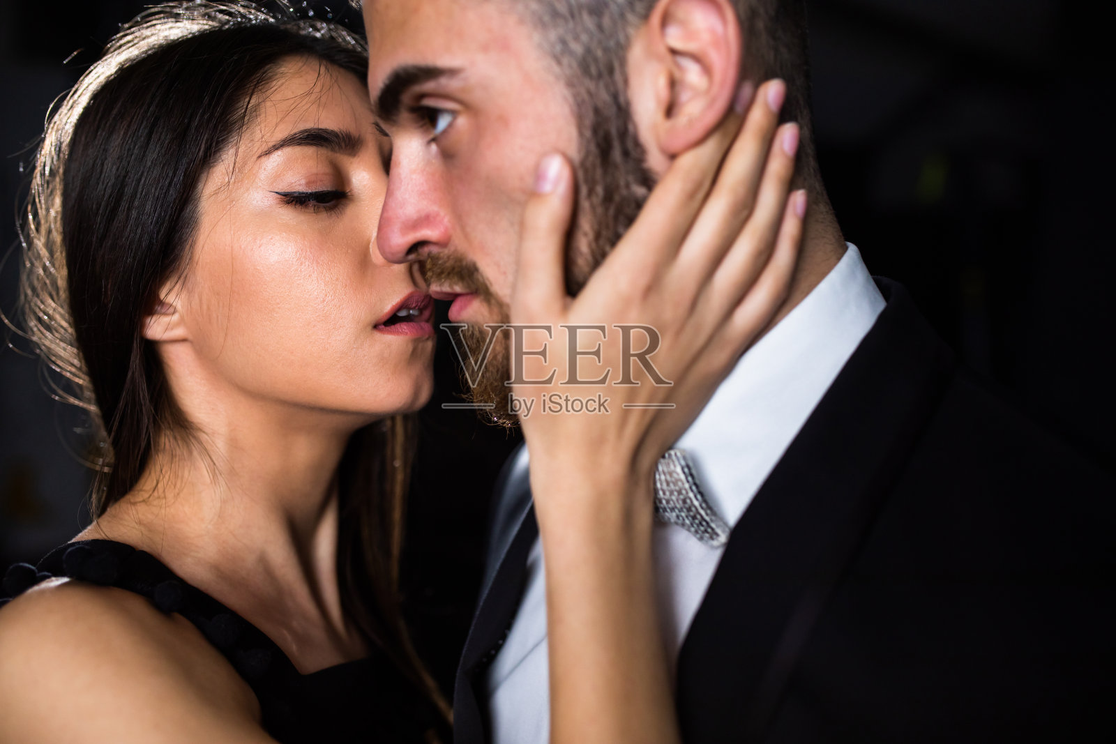 一位年轻女子正要亲吻一位英俊的年轻男子照片摄影图片