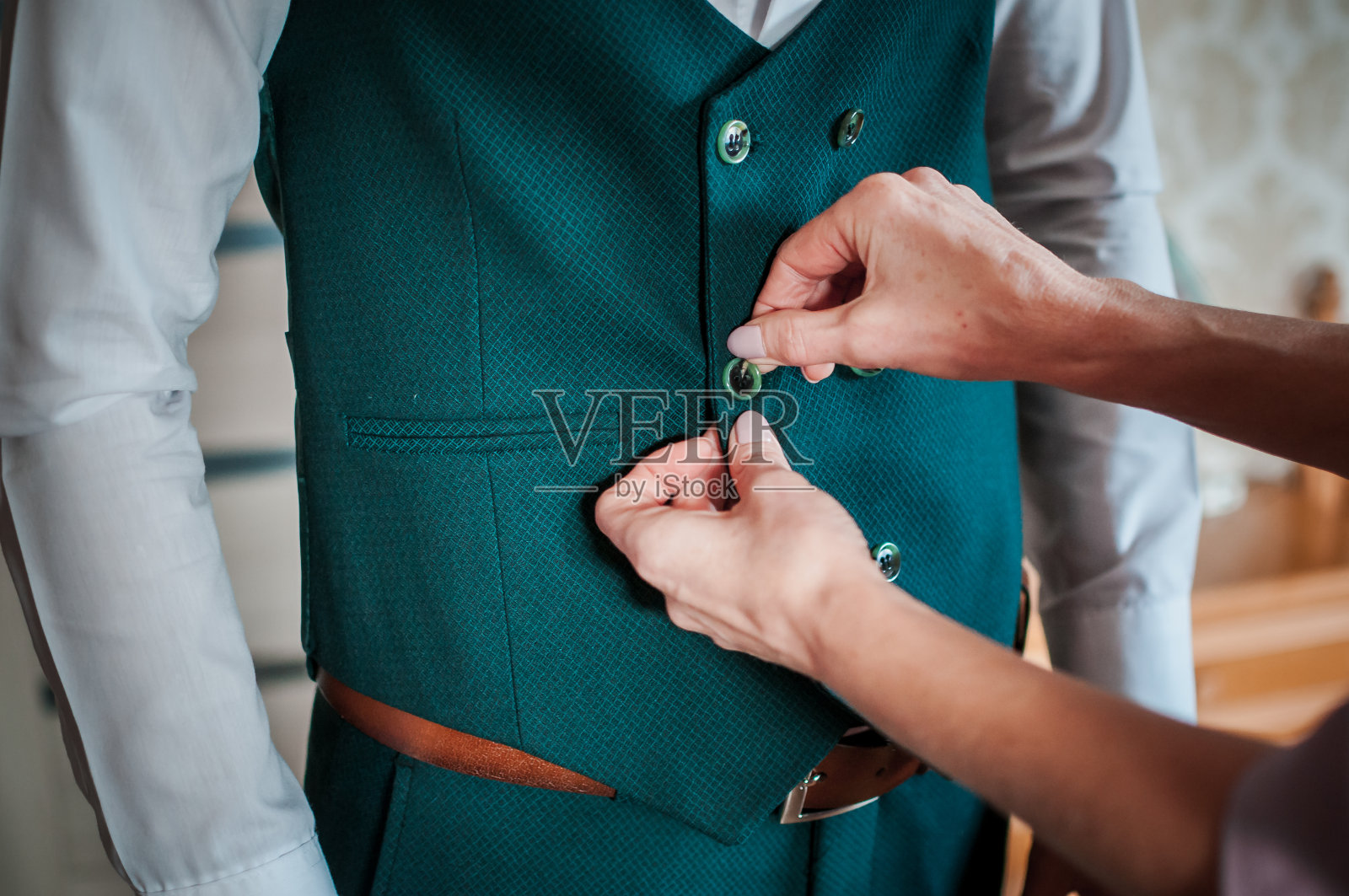 妈妈正在给新郎系扣子照片摄影图片