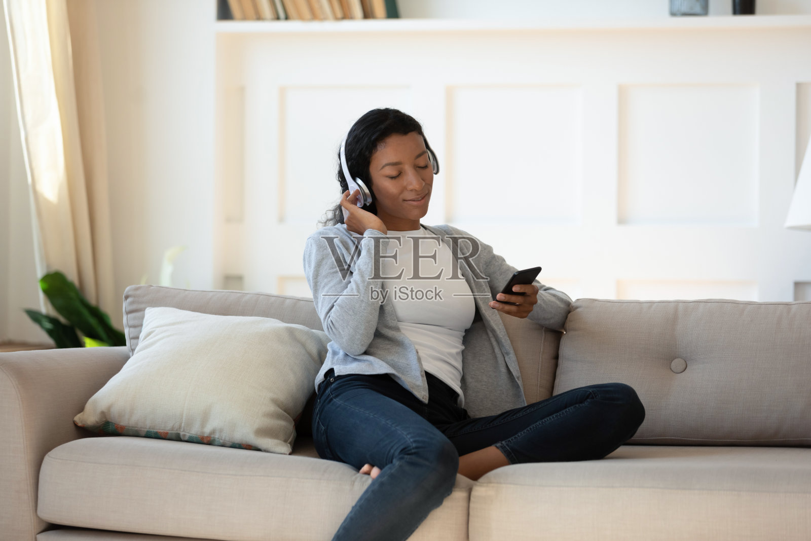 冷静的混血女性在智能手机上听音乐照片摄影图片