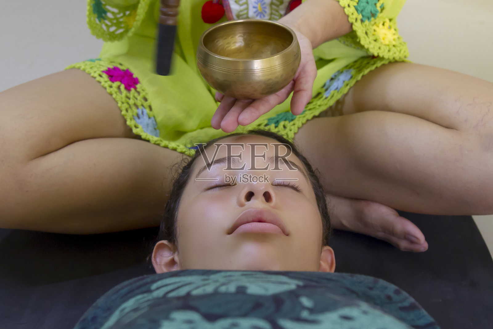 中年女子在室内演奏颂钵，为青少年治疗照片摄影图片