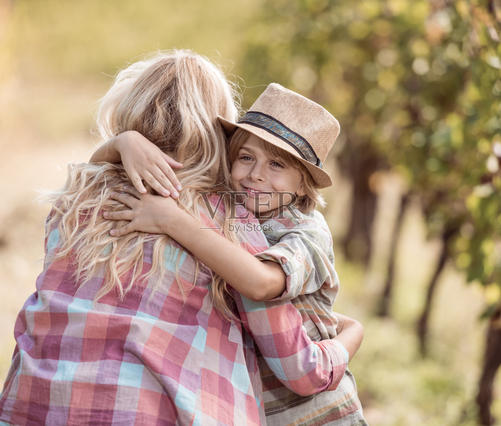 母亲在葡萄园里拥抱儿子照片摄影图片